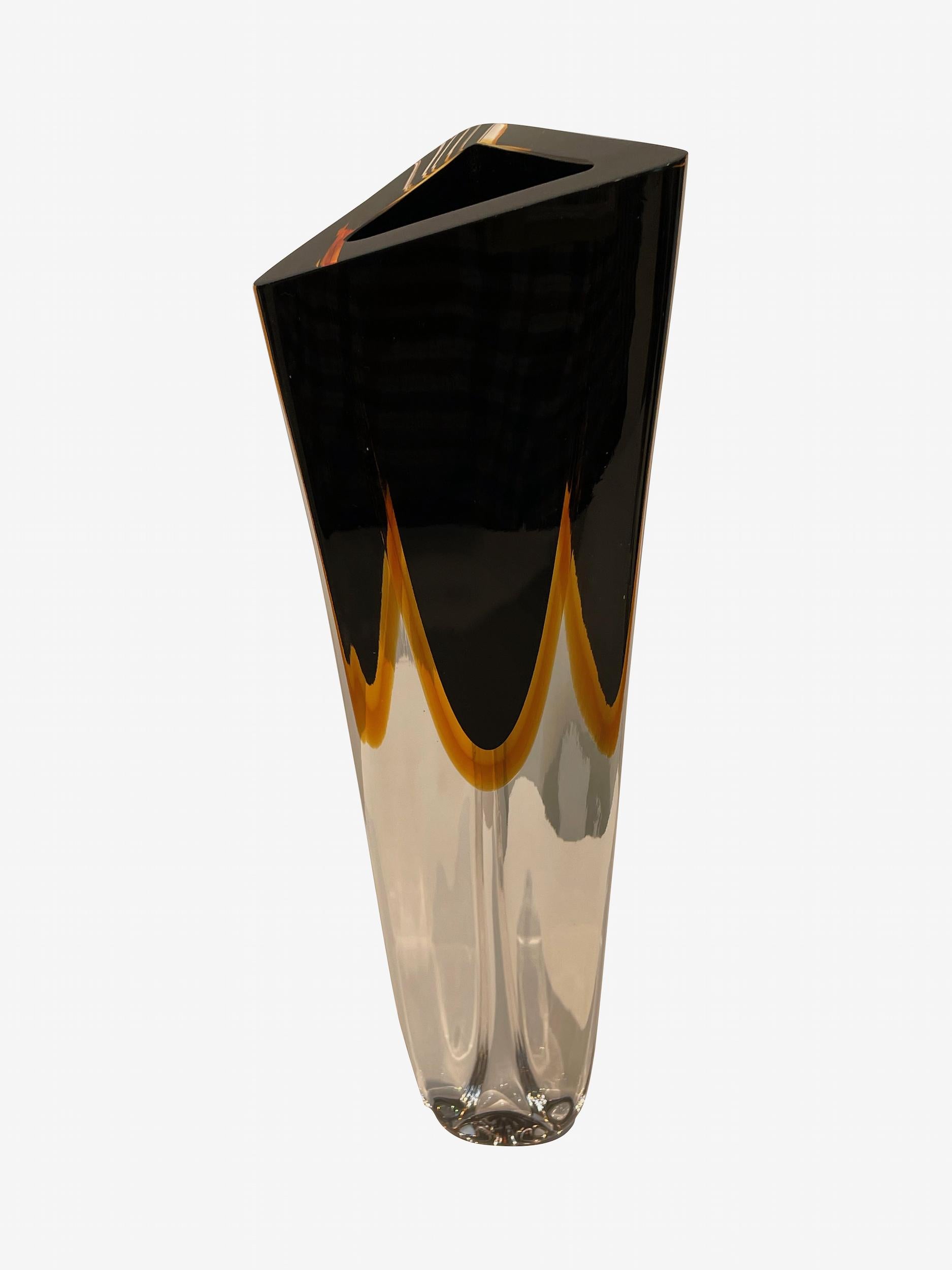 Contemporary Brazilian tall thick glass vase with triangular shaped opening.
Black glass with amber colored accents.
Sits nicely with shorter version ( S6998) and rounded style (S7000)