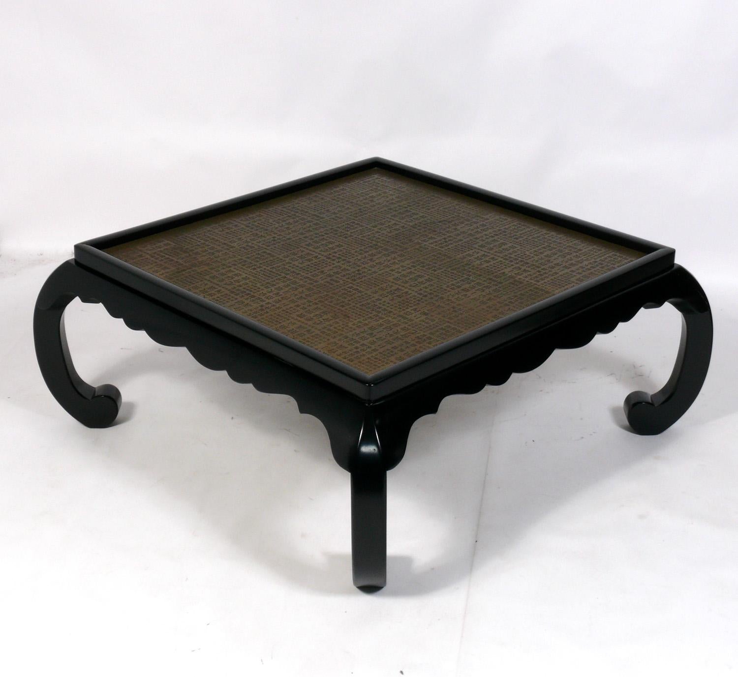 Elegant brass and black Lacquer coffee table, in the manner of Philip and Kelvin Laverne, American, circa 1960s. The black lacquer wood frame has been recently refinished and the brass top imprinted with Chinese characters retains it's warm original