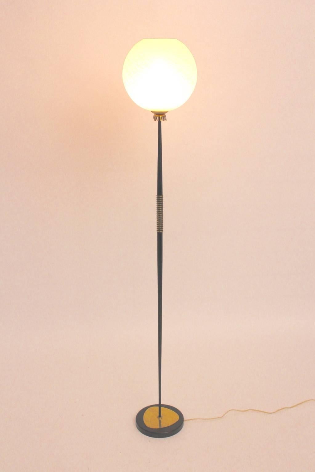 Mid century modern vintage floor lamp, which was designed and manufactured in Vienna, 1950s.
The conical stem was made of cast iron and metal - black lacquered with nice brass details.
The globe glass shade was made of textured glass.
The floor lamp