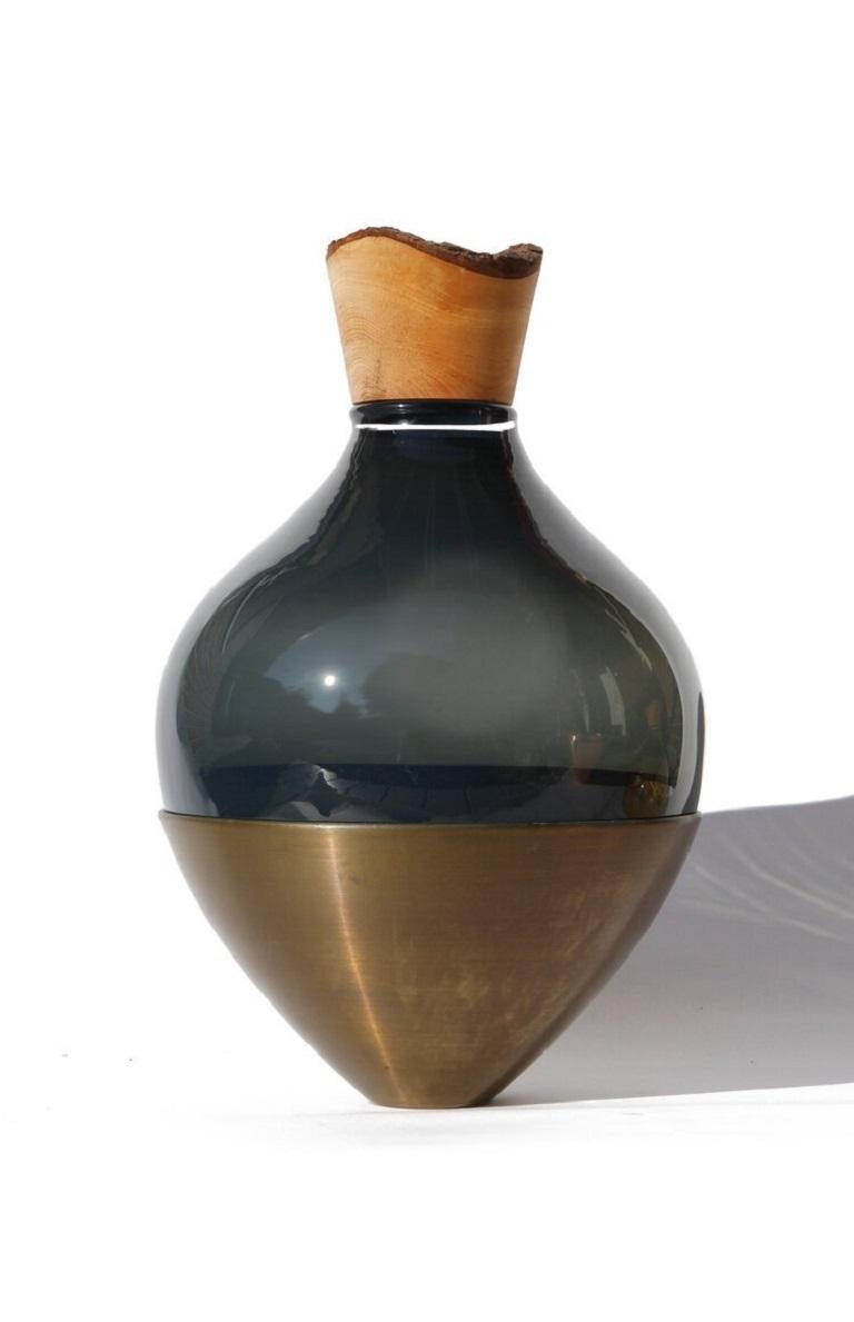 Black and Brass Patina India Vessel II, Pia Wüstenberg.
Dimensions: D 20 x H 38.
Materials: glass, wood, brass.
Available in other metals: brass, copper, brass patina, copper patina, rust.

Handmade in Europe, by individual craftsmen: handblown