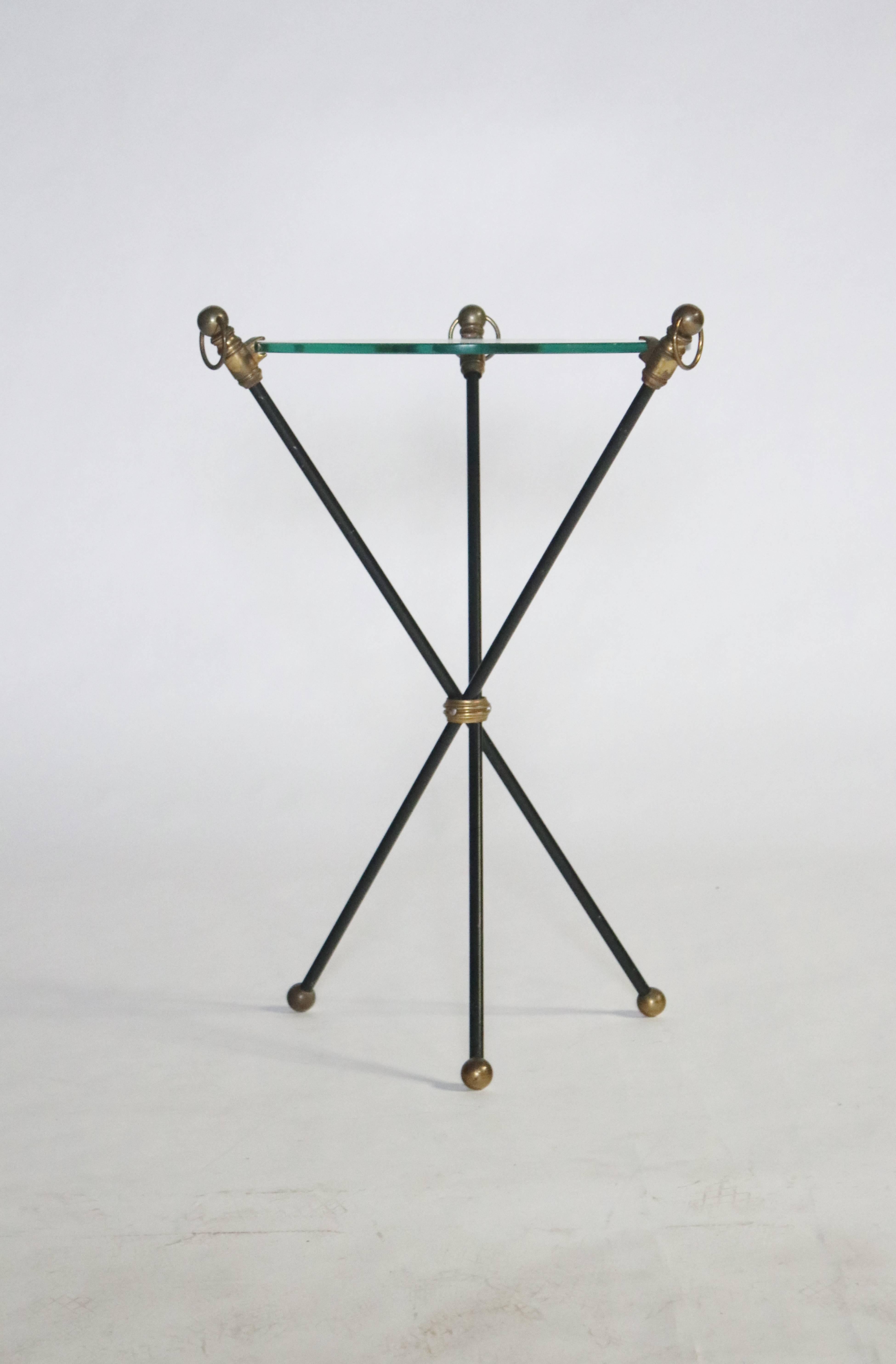 Black midcentury tripod table features brass accents, ball feet and a glass top.