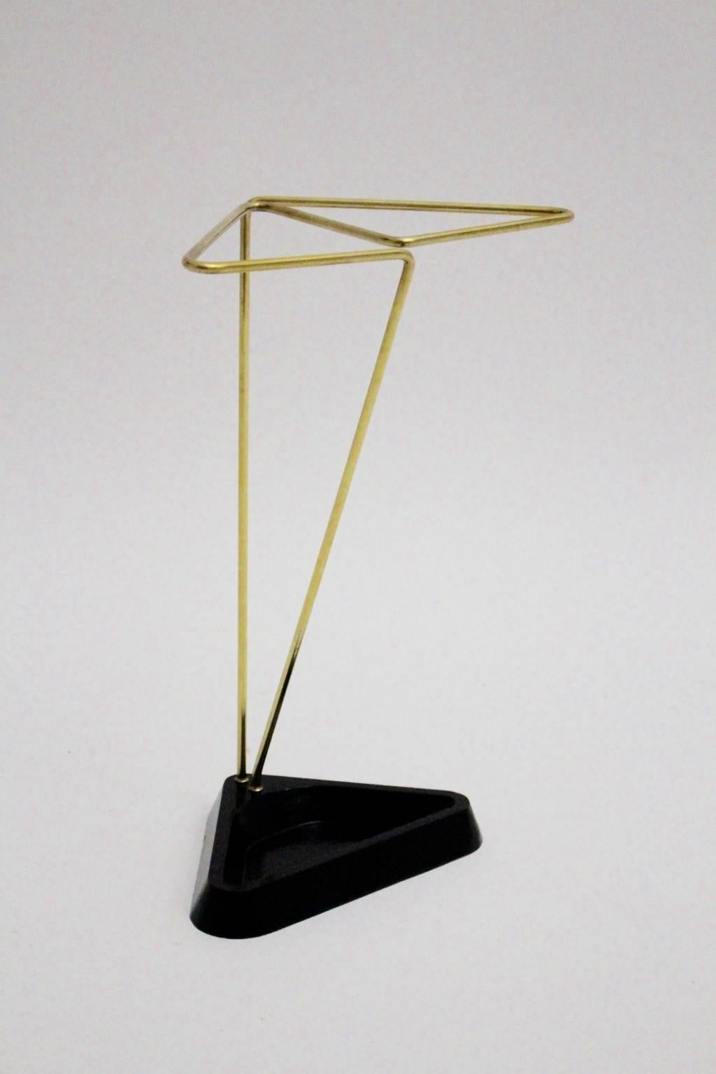 Mid century Modern vintage umbrella stand from black cast iron and brass details in triangle like shape.
The vintage condition is very good.

approx. measures:
Width 26.5 cm
Depth 16 cm
Height 40 cm.