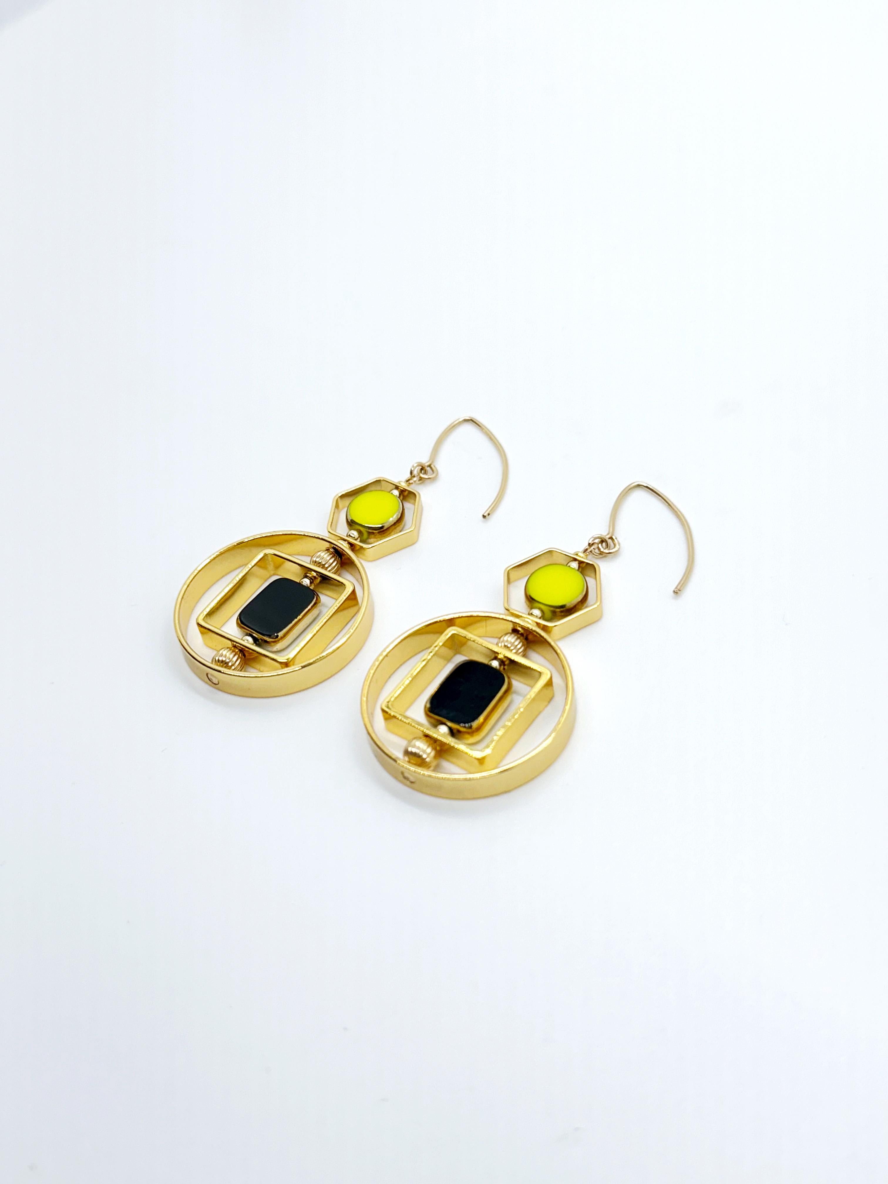 The earrings are lightweight and are made to rotate and reposition with movement.

The earrings consists of black and chartreuse new old stock vintage German glass beads framed with 24K gold. The beads were hand-pressed during the 1920s-1960s in