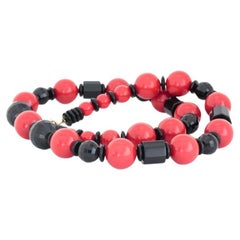 Collier de perles en plastique noir et rouge cerise
