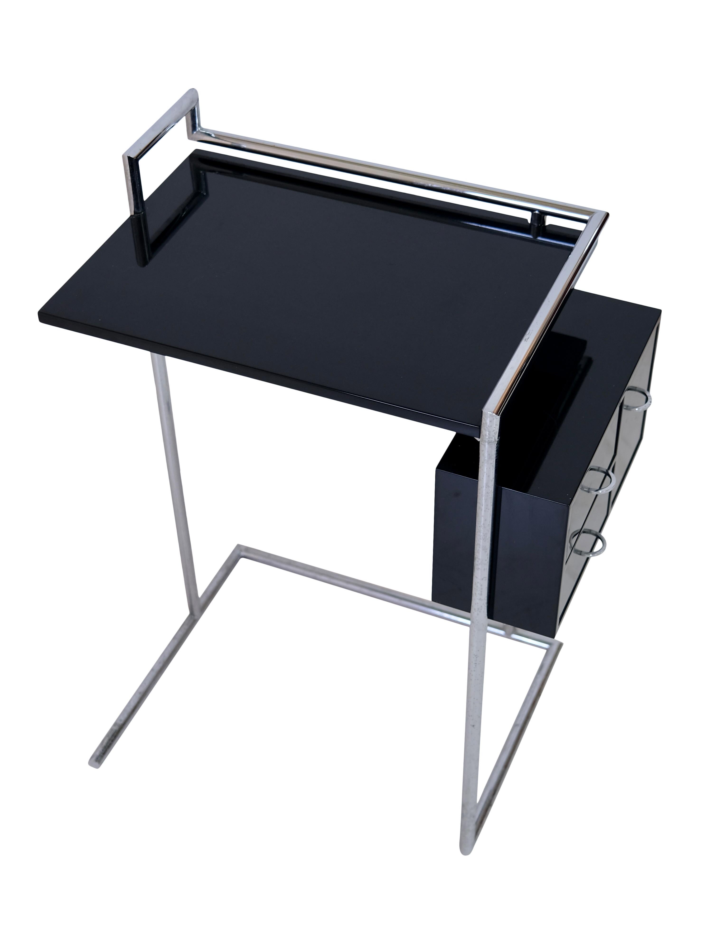 Coiffeuse by Eileen Gray

Design classic, design from 1926 by Eileen Gray
Manufacturer: ClassiCon (licensed)
Germany, 1990s

Panels in black with chrome-plated steel tubes
Swinging drawers

Dimensions:
Width: 64 cm
Height: 84 cm
Depth: 40 cm
Working