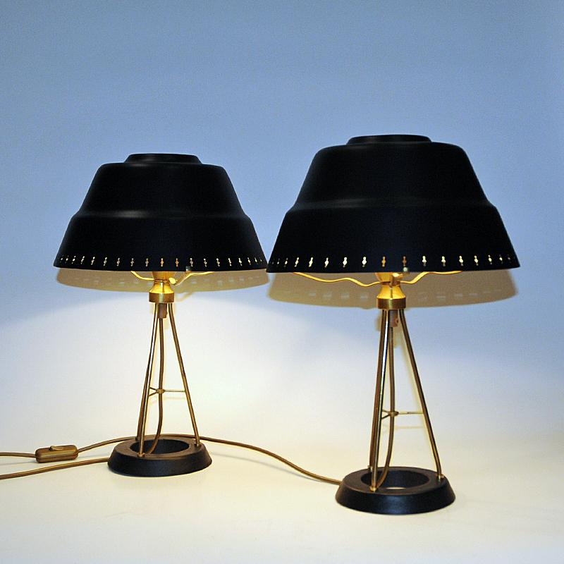 Hübsches und klassisches Paar Tischlampen aus Metall mit drei Stablampenkörpern aus Messing und großen schwarzen Metallschirmen mit durchbrochenen Randlöchern für den Lichtfluss. Produziert von der Uppsala Armaturfabrik in den 1950er Jahren. Sieht