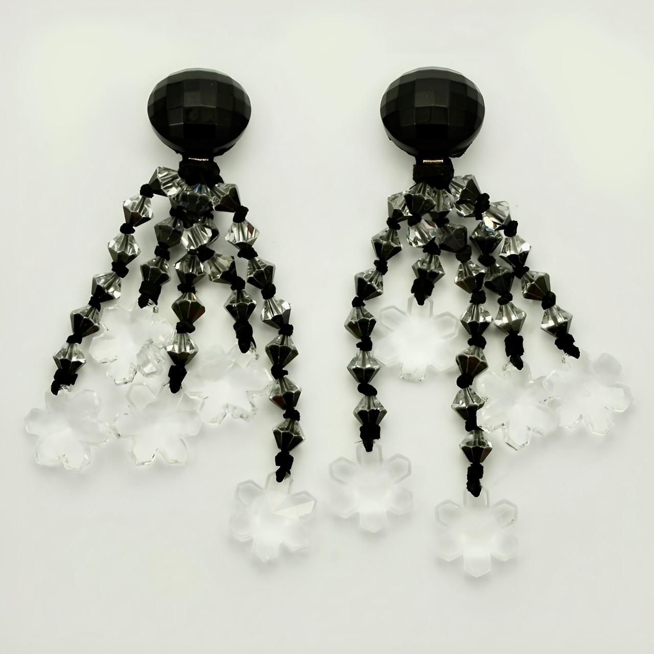 Fabulous silver tone chandelier earrings, featuring five faceted black and clear glass strands, finishing with a clear glass flower. The clip top is faceted black glass. Measuring length 11 cm / 4.3 inches. There are some small chips to the flowers,