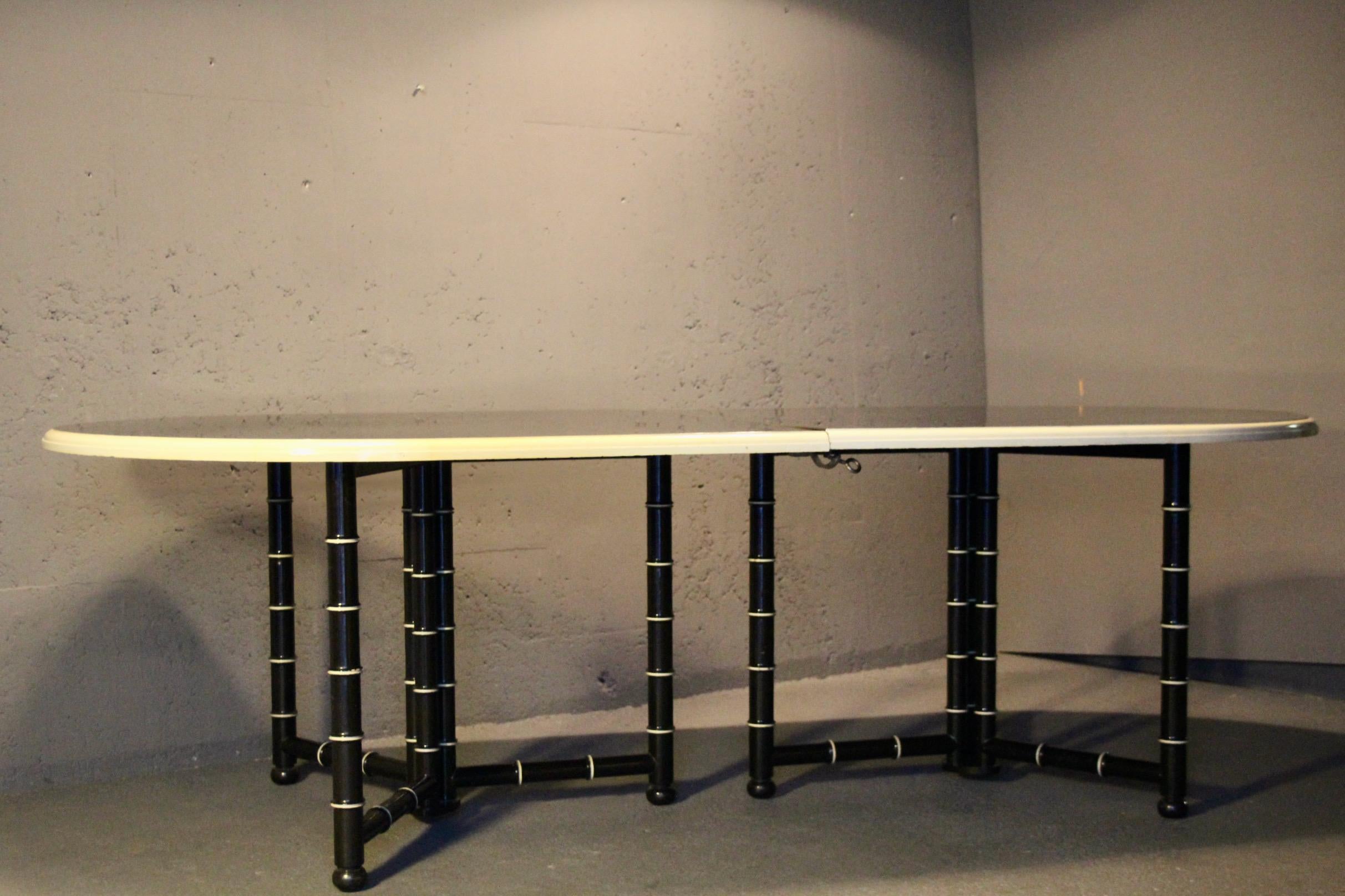 Table de salle à manger en bois laqué noir et crème avec 3 rallonges, chaque rallonge a des pieds qui se replient pour une longueur exceptionnelle de 240 cm à 420 cm la qualité est belle probablement faite par Maison Jansen France