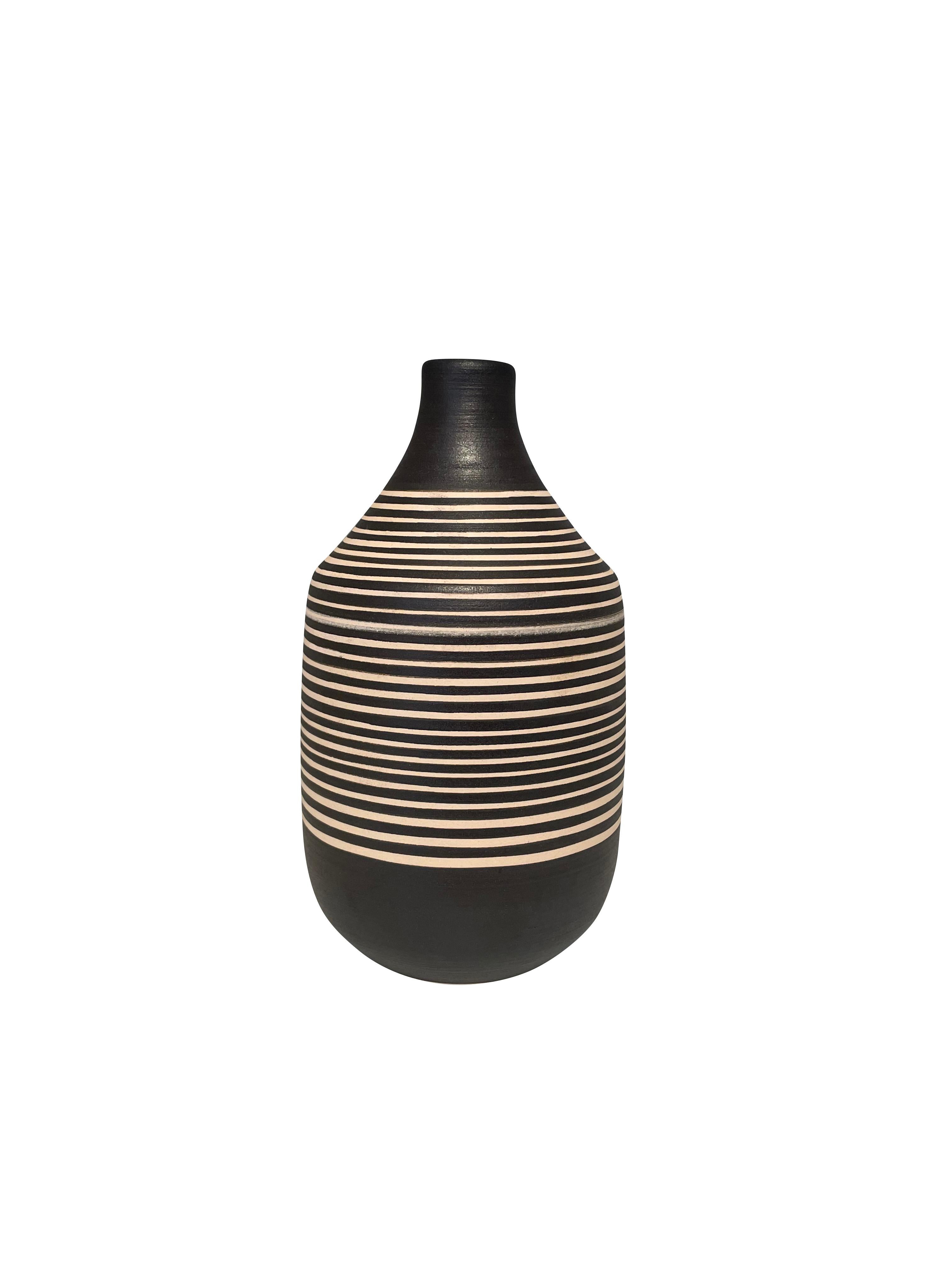 Contemporary Turkish hand made black & cream thin horizontal striped vase.
Wide opening.
Can hold water.
Two available.
Part of a large collection.