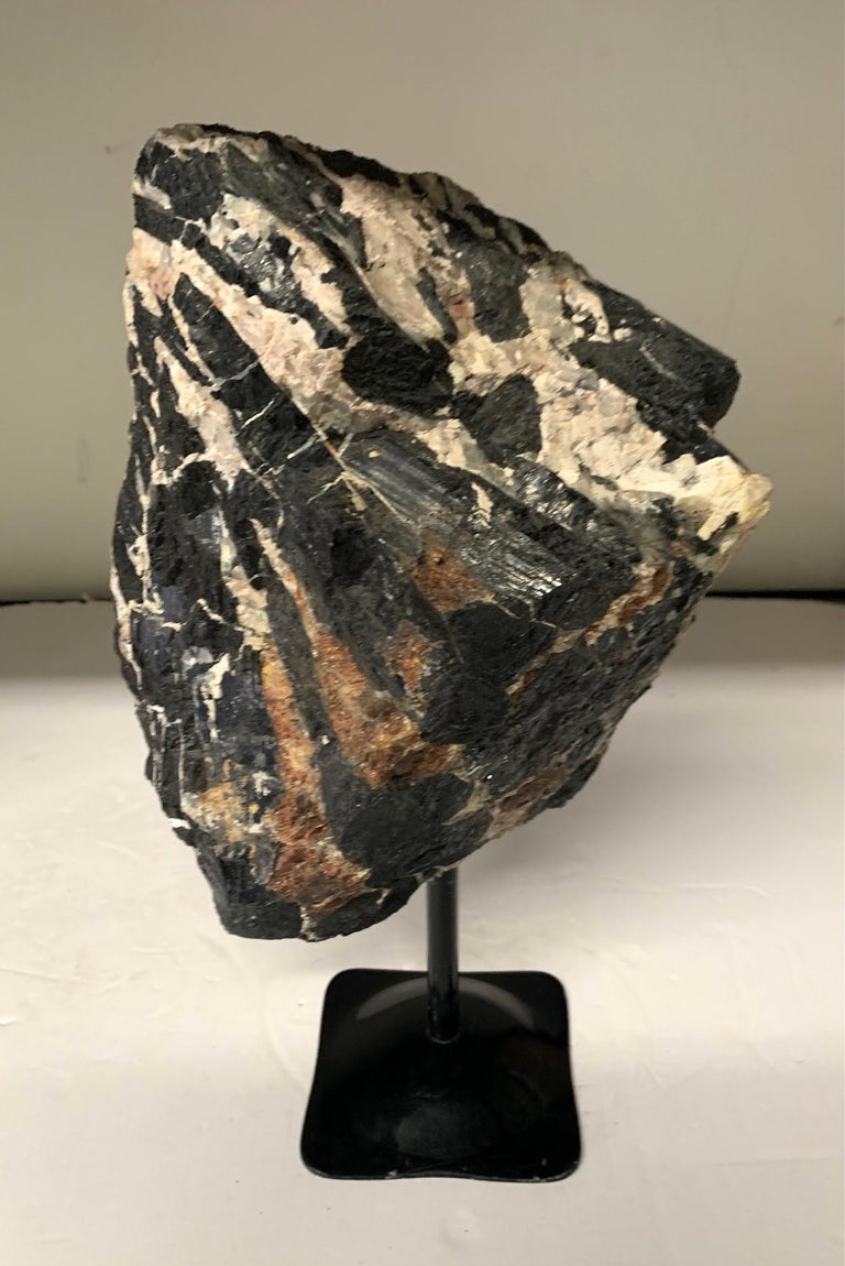 Brazilian large black cut tourmaline stone on stand.
Black mixed with cream.
Black Tourmaline is a stone often used for protection. 
It's a great stone for soaking up negative energies .
Stand measures 4