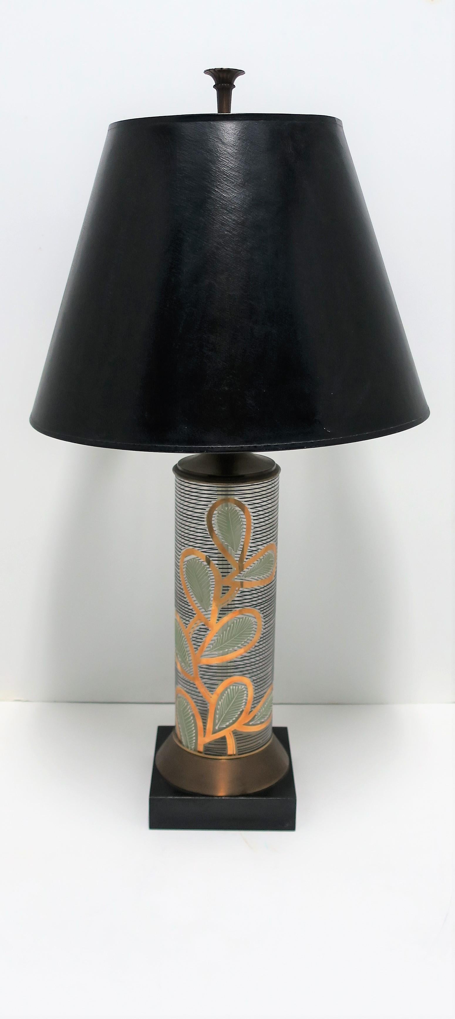 A very beautiful, tall, glass and brass table lamp with an organic modern design in black and gold, circa mid-20th century, Europe. Lamp is of the Mid-century Modern period. Lamps' design is a 'raised' relief on a cylindrical glass body; a beautiful