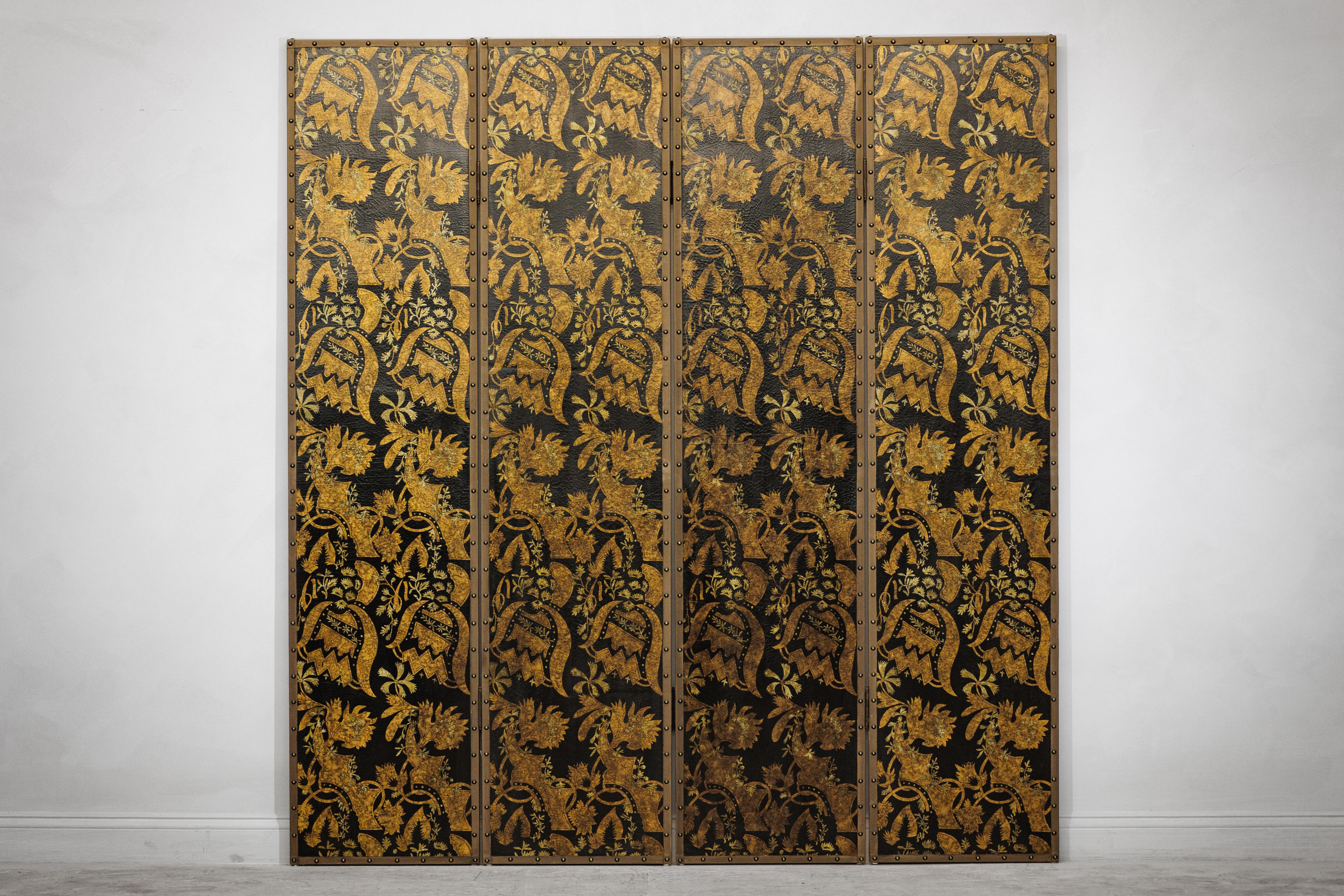 Dieser vierteilige Paravent aus China im Vintage-Stil weist eine reich strukturierte Oberfläche auf, die mit einem sich wiederholenden Blumen- und Blattmotiv in Gold vor einem tiefschwarzen Hintergrund verziert ist. Stilisierte Blüten, geschwungene