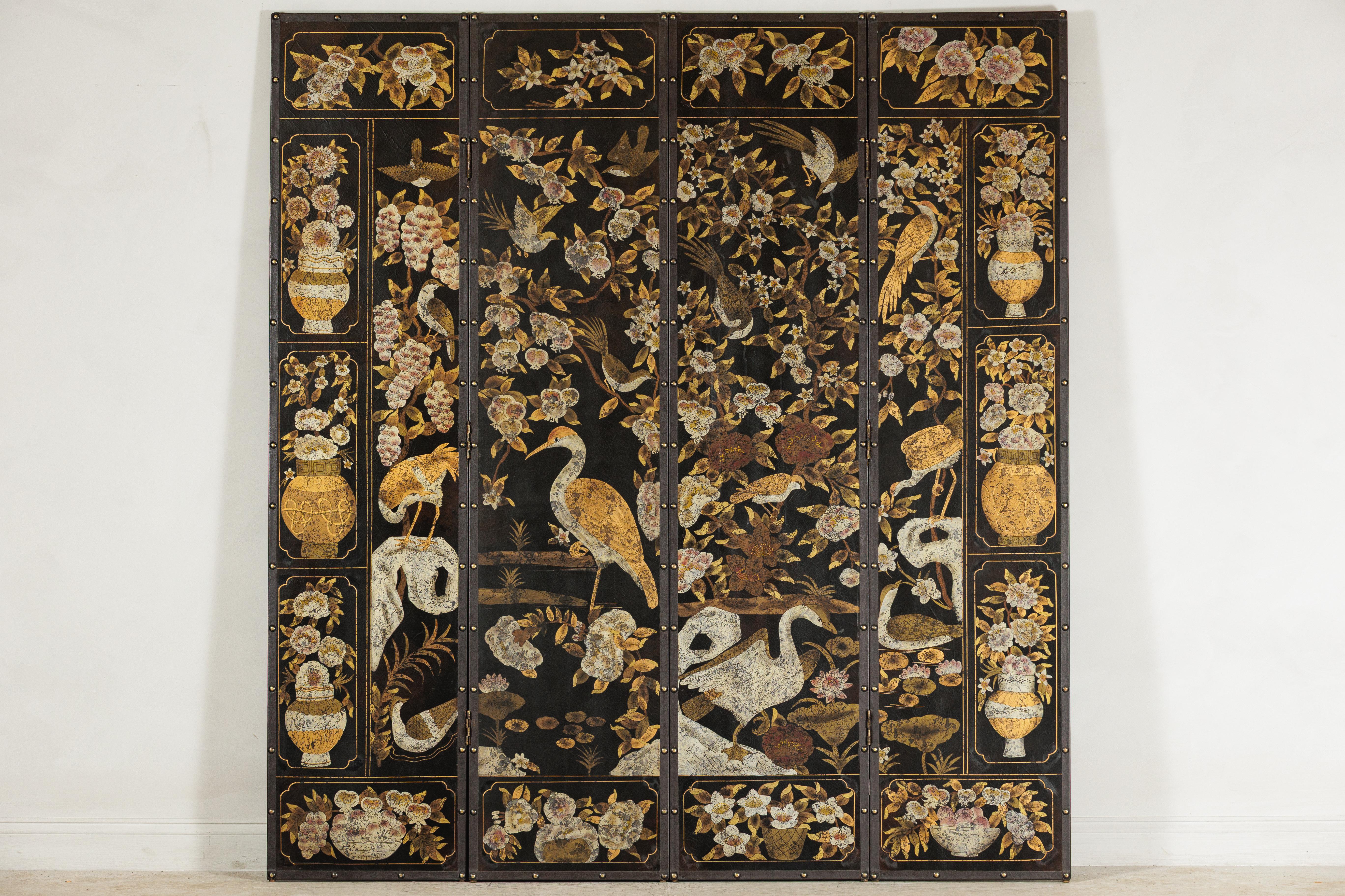 This vintage four-panel Chinese screen features a richly painted scene of cranes, flowering branches, and ornamental vases set against a deep black ground. Executed in layered pigments and gold accents, the surface is decorated in a traditional