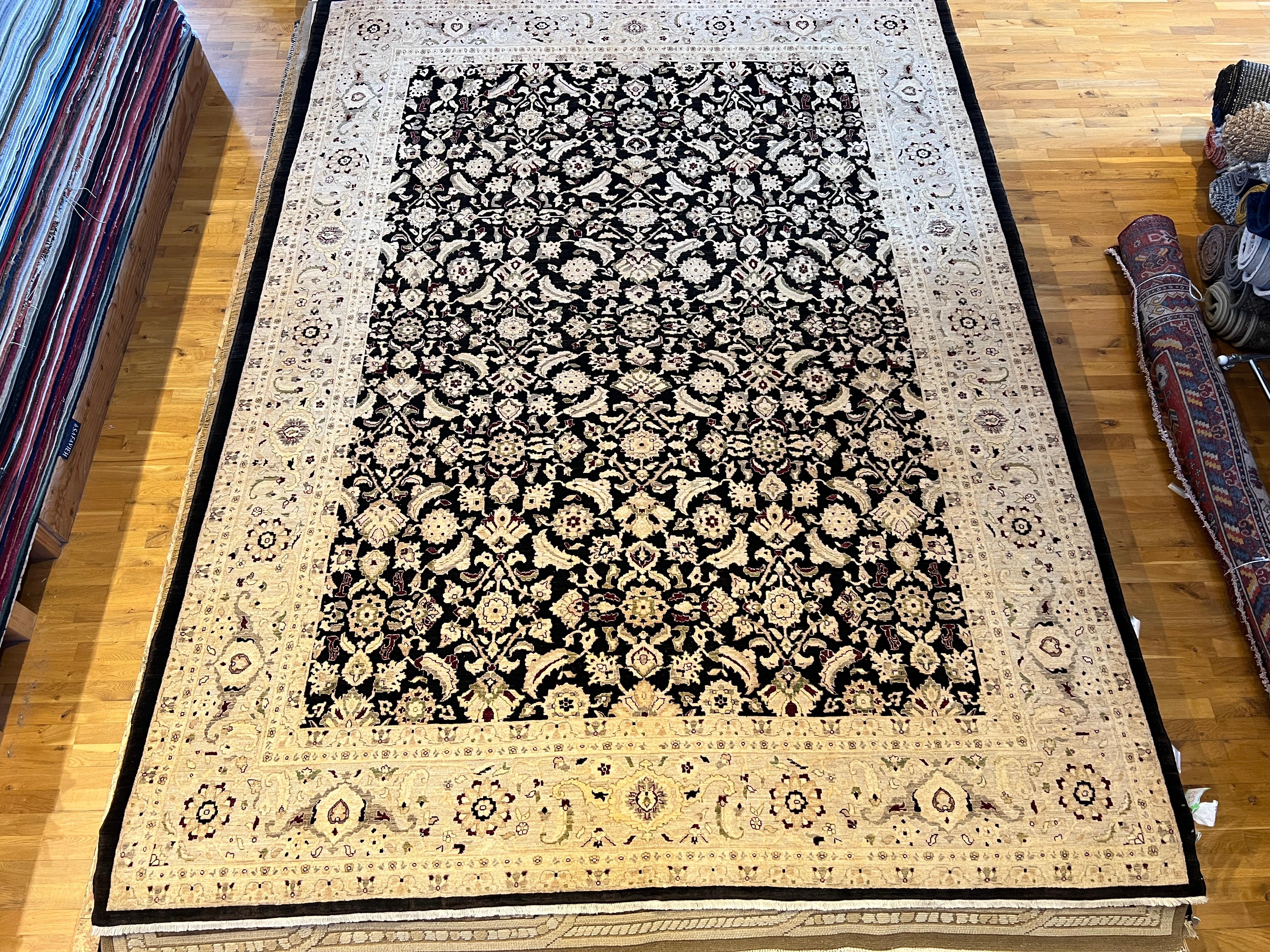 Ce tapis 9'x12' noué à la main par des experts présente un design floral complexe en noir et or, parfait pour ajouter une touche d'élégance à n'importe quelle pièce. Fabriqué à partir de laine de haute qualité et de teintures naturelles, ce tapis