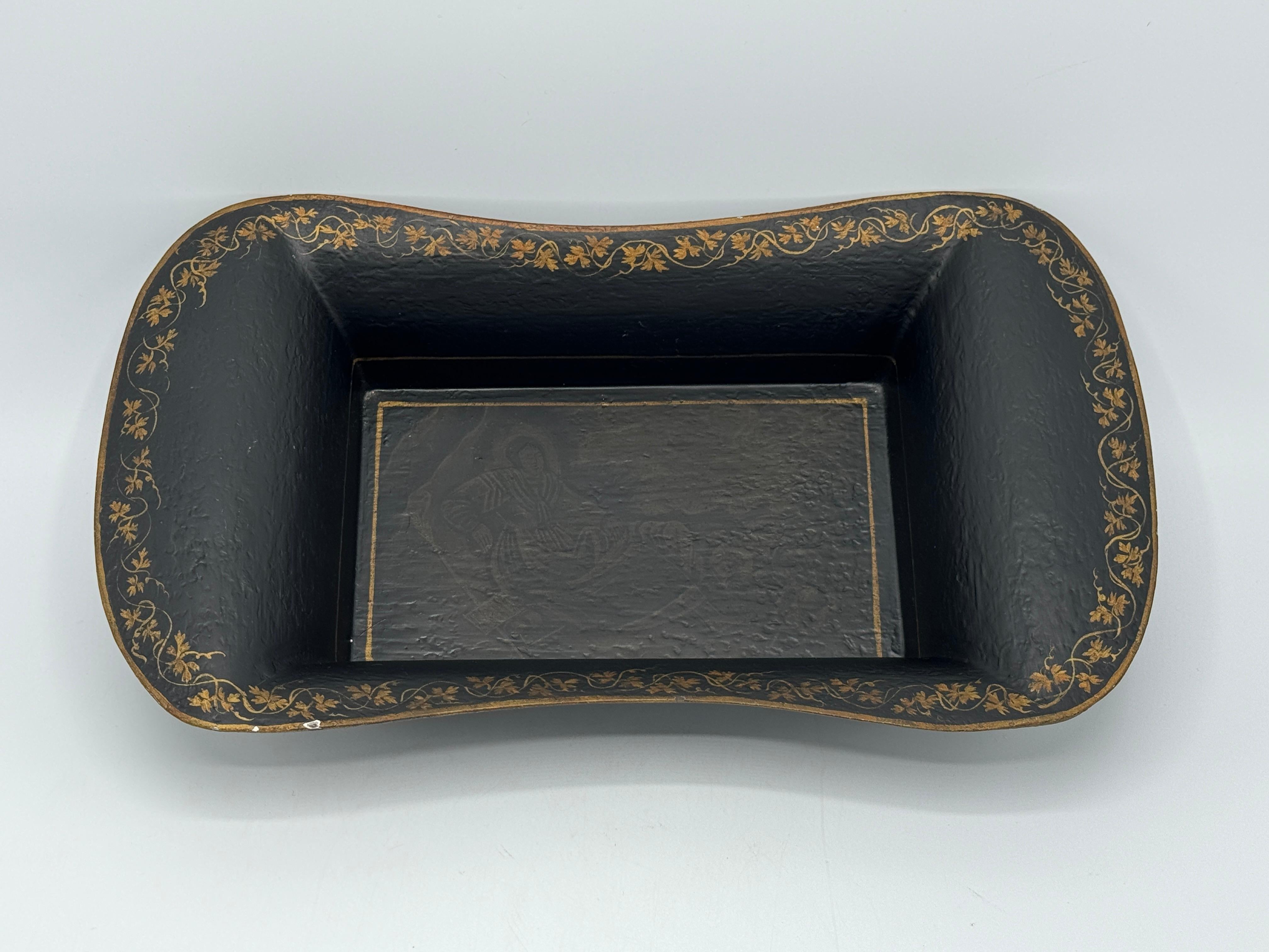 Offered is a beautiful, late 20th Century Italian tole decorative bowl. The piece features and hand-painted black and gold border of vines with a Chinoiserie scene along the bottom of the dish. 