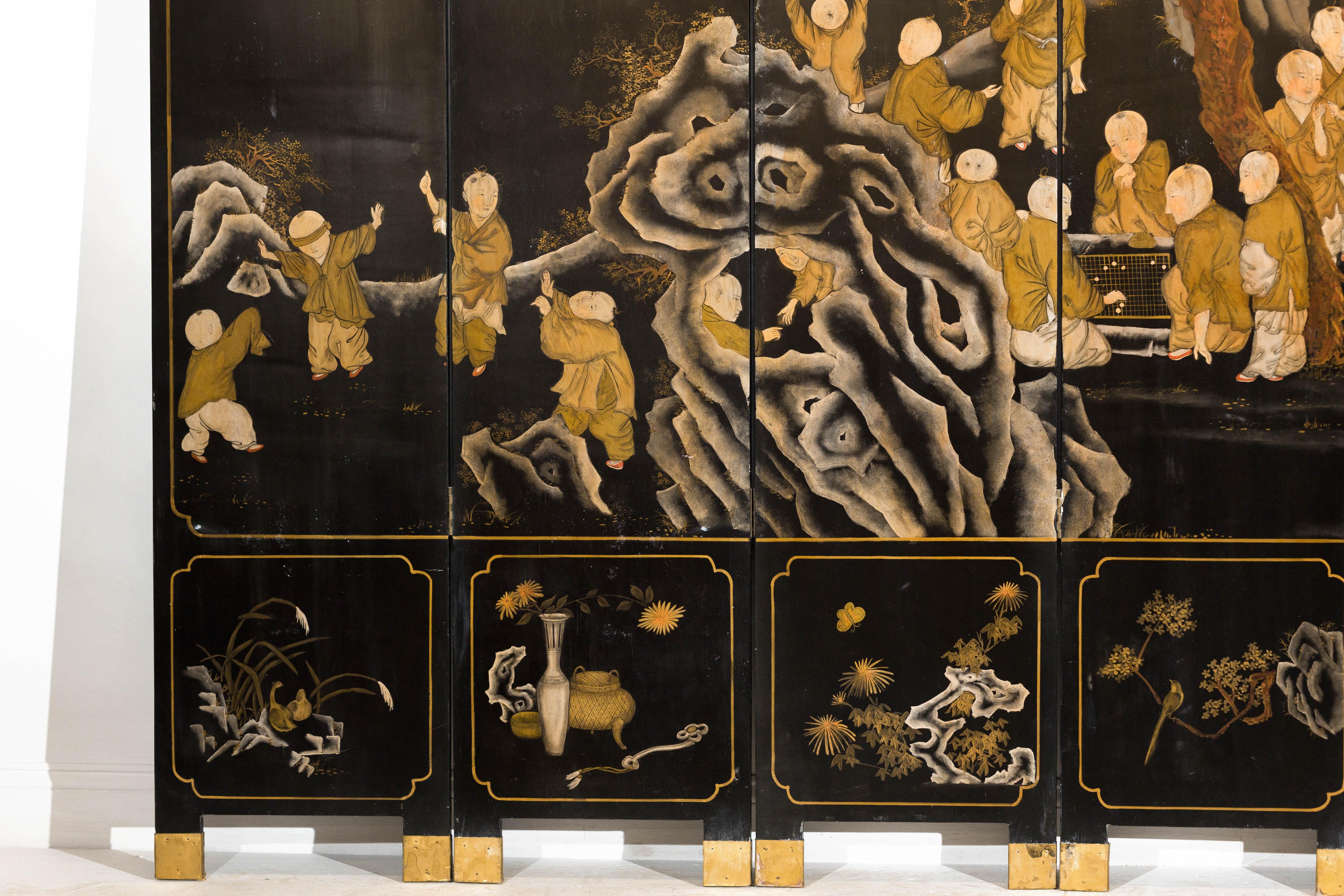 Ottone Paravento a otto pannelli laccato nero e oro con scena di monaci e bambini in vendita