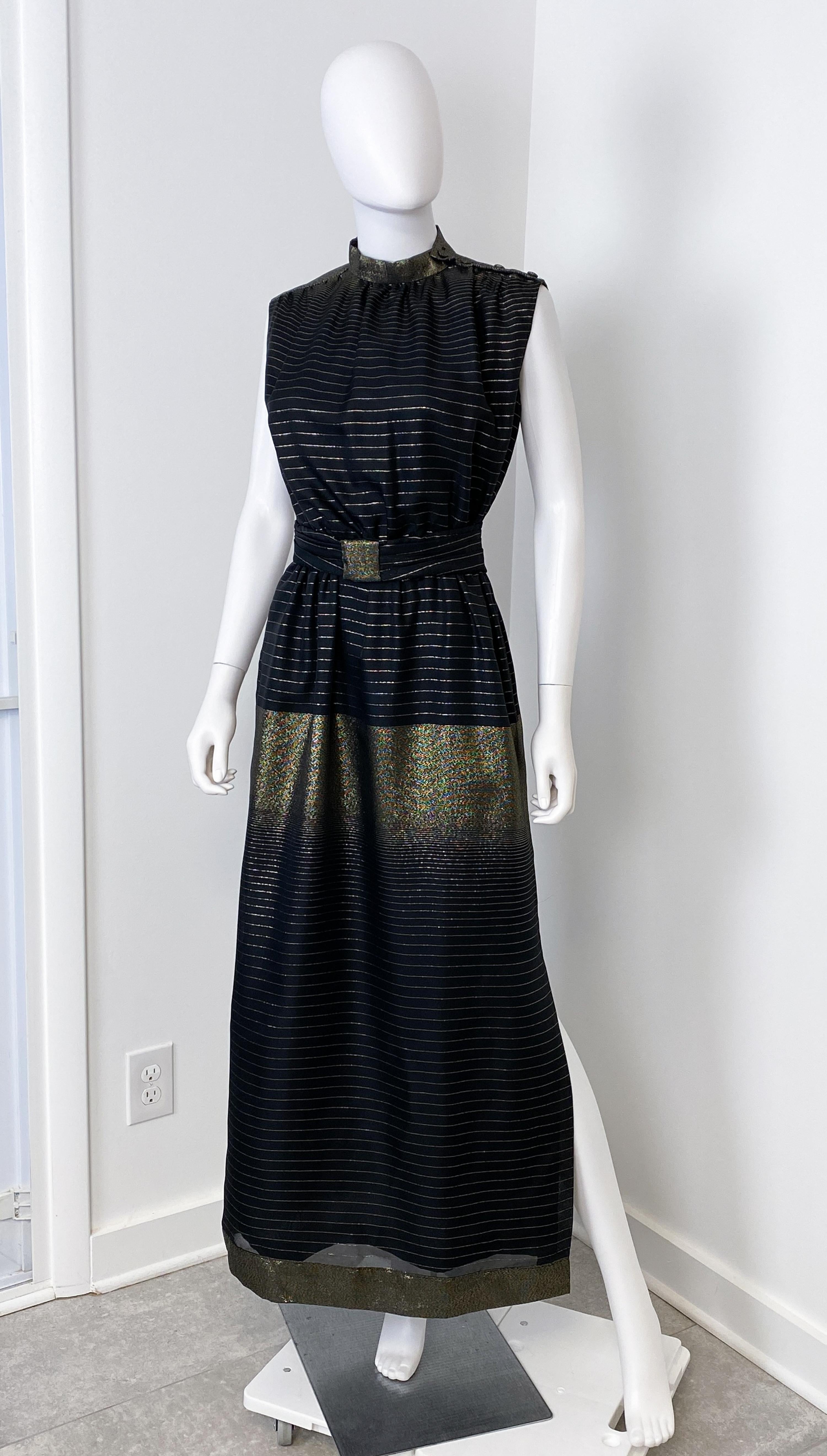 This is a lovely vintage black and gold lamé evening dress from the 1980s. The broad horizontal gold lamé irregular stripe strikes a bold figure, and the dress has a sleeveless finish and buttons on the shoulder. The assorted belt is in the same