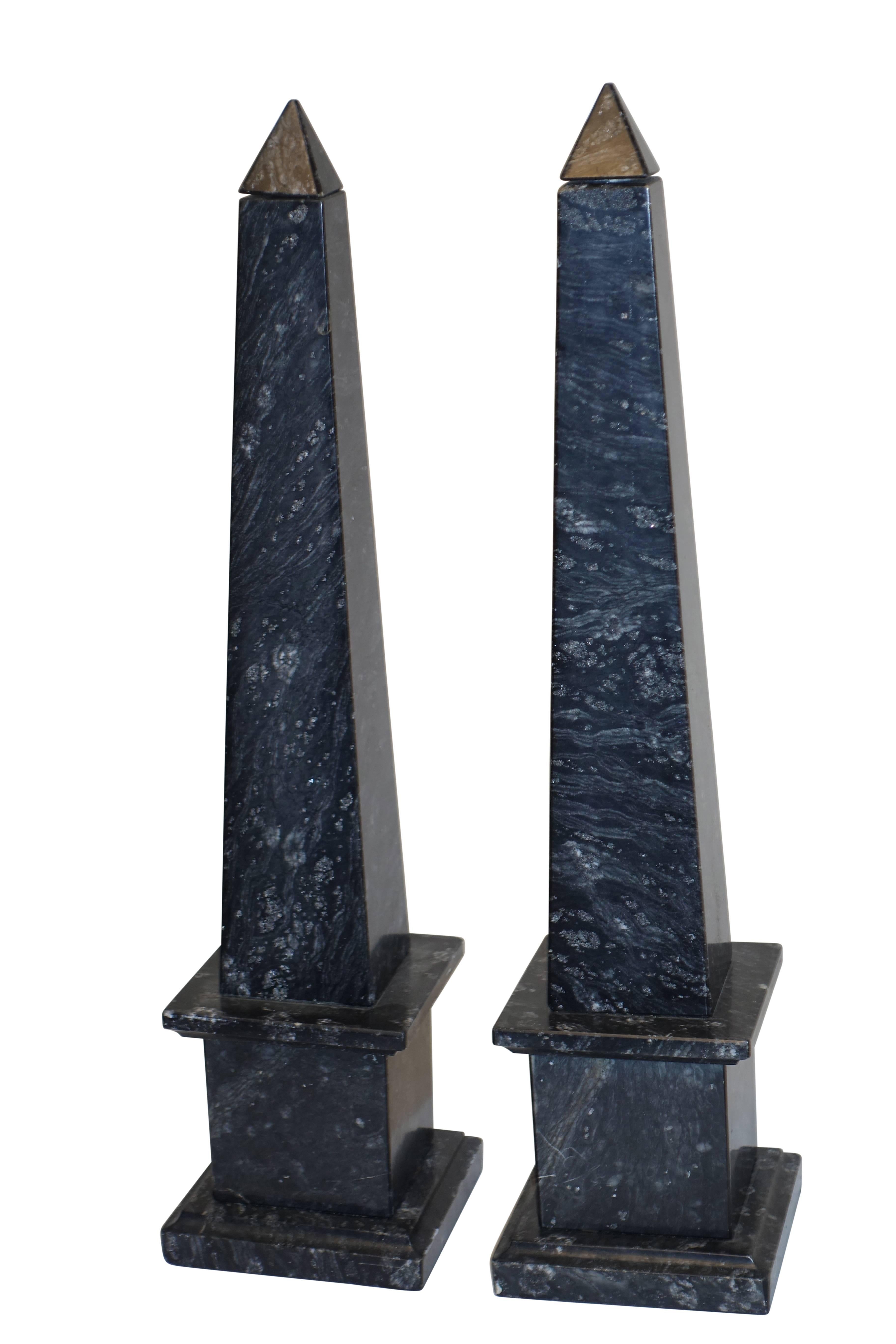 A pair of black marble obelisks with gray veining and fossilized inclusions. These were lamps with the peaked top of the obelisk as the lampshade finial. Could be wired again for lamps if desired. Italy, mid-20th century.