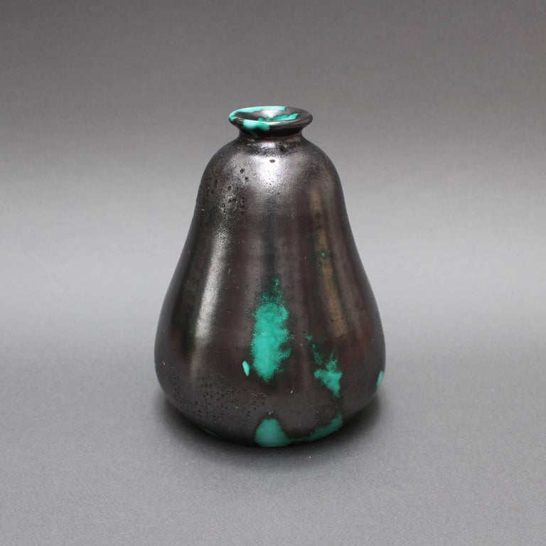 Black and green ceramic Primavera vase by C.A.B. (Céramique d’art de Bordeaux) for Printemps (circa 1930s). This pear-shaped vase with narrow mouth is completely enchanting. The green colored base is virtually covered by a metallic black enamel
