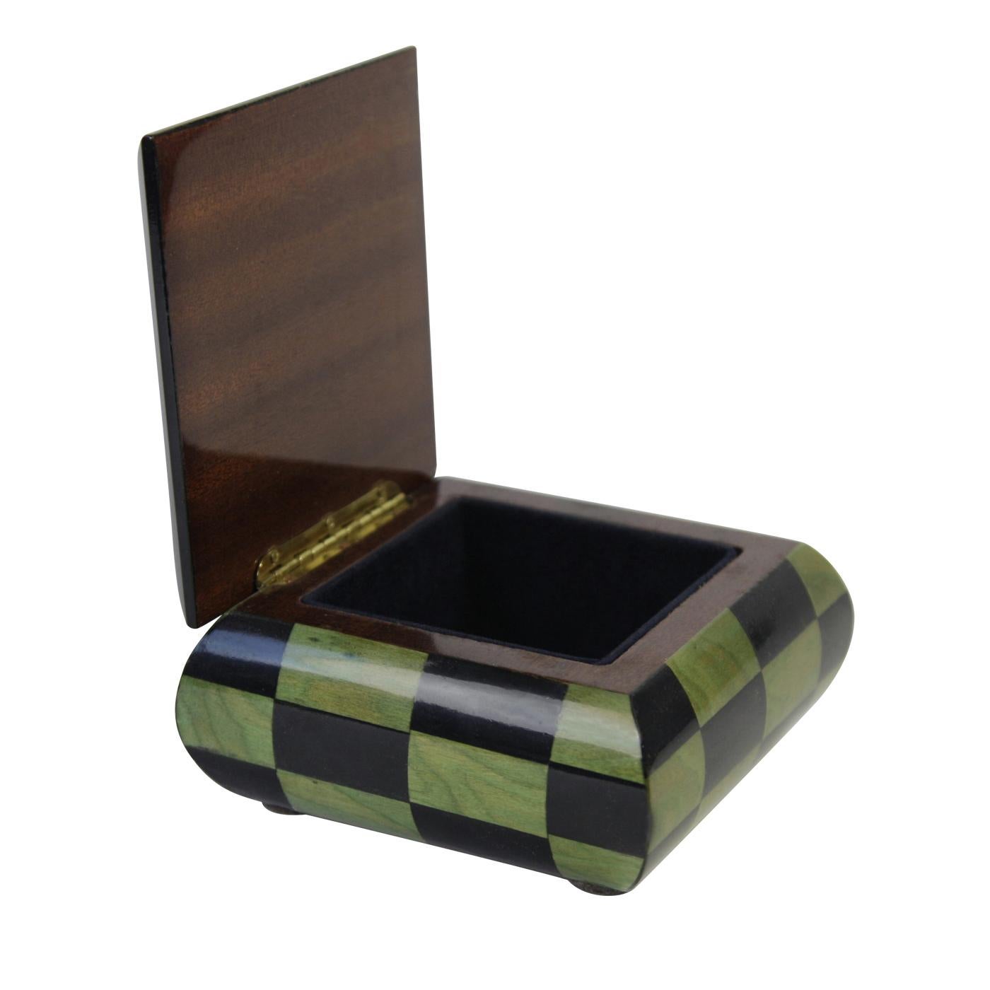 This elegant wooden box is a music box, entirely hand-manufactured according to the ancient traditional techniques of Sorrento marquetry. The exterior is in elegant dark wood, while the lid is decorated with a chess-like pattern of diamonds. Upon