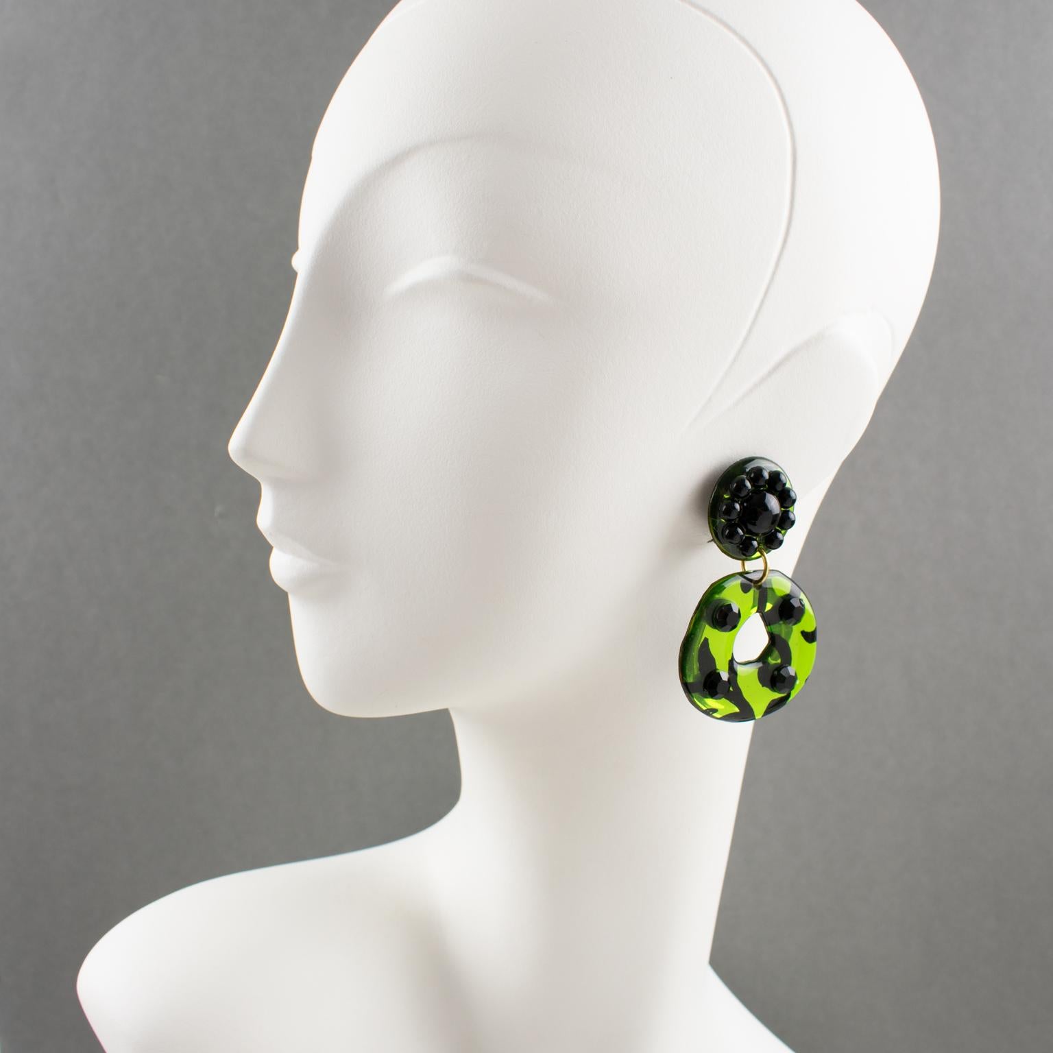 These incredible Italian designer studio Lucite or resin dangling clip-on earrings feature a massive donut shape in a shamrock green mirrored textured pattern contrasted with black stripes and topped with licorice black crystal rhinestones. The clip