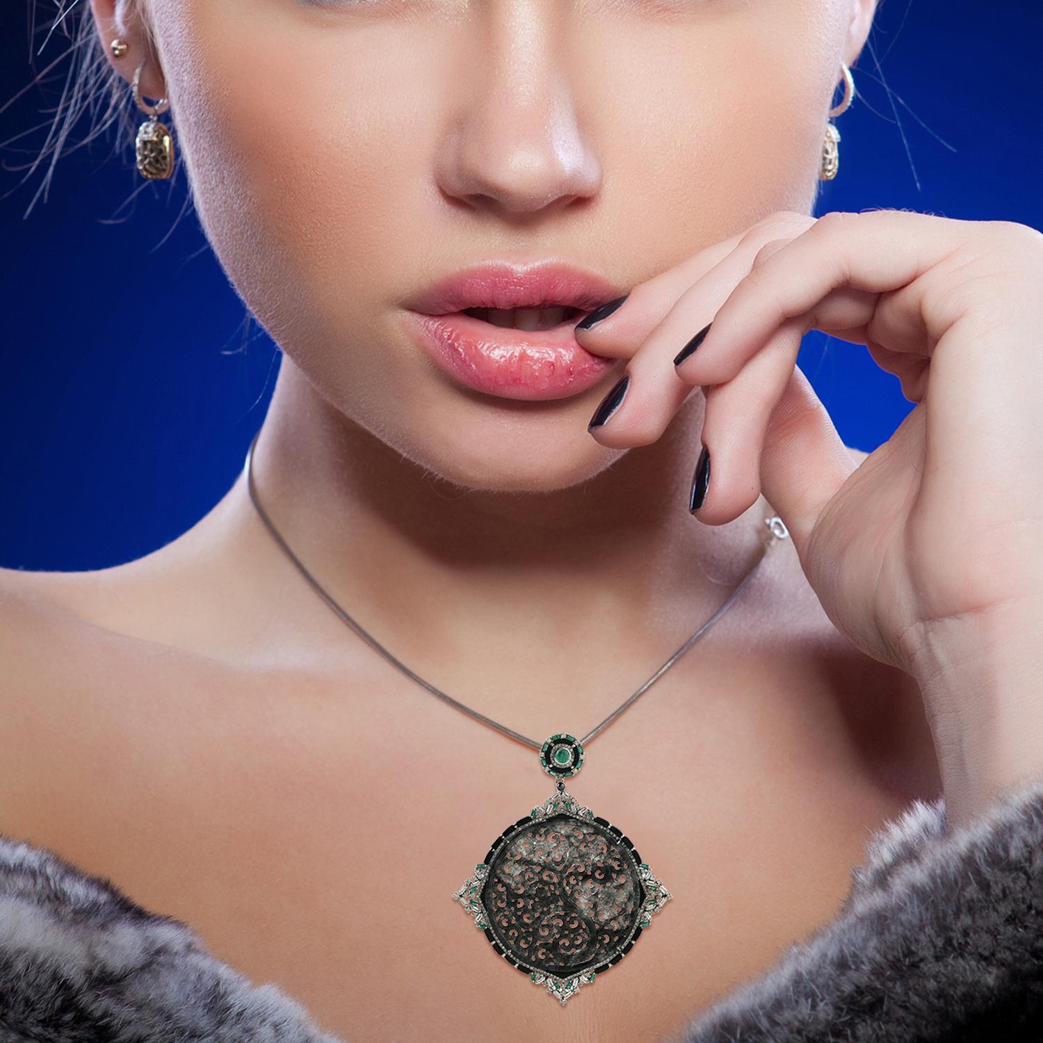 Il bellissimo pendente di giada nera e grigia intagliata, unico nel suo genere, con diamanti rotondi e baguette e smeraldi incastonati in oro bianco 18 carati e argento, è un pendente adorabile e audace e può essere abbinato a qualsiasi catena