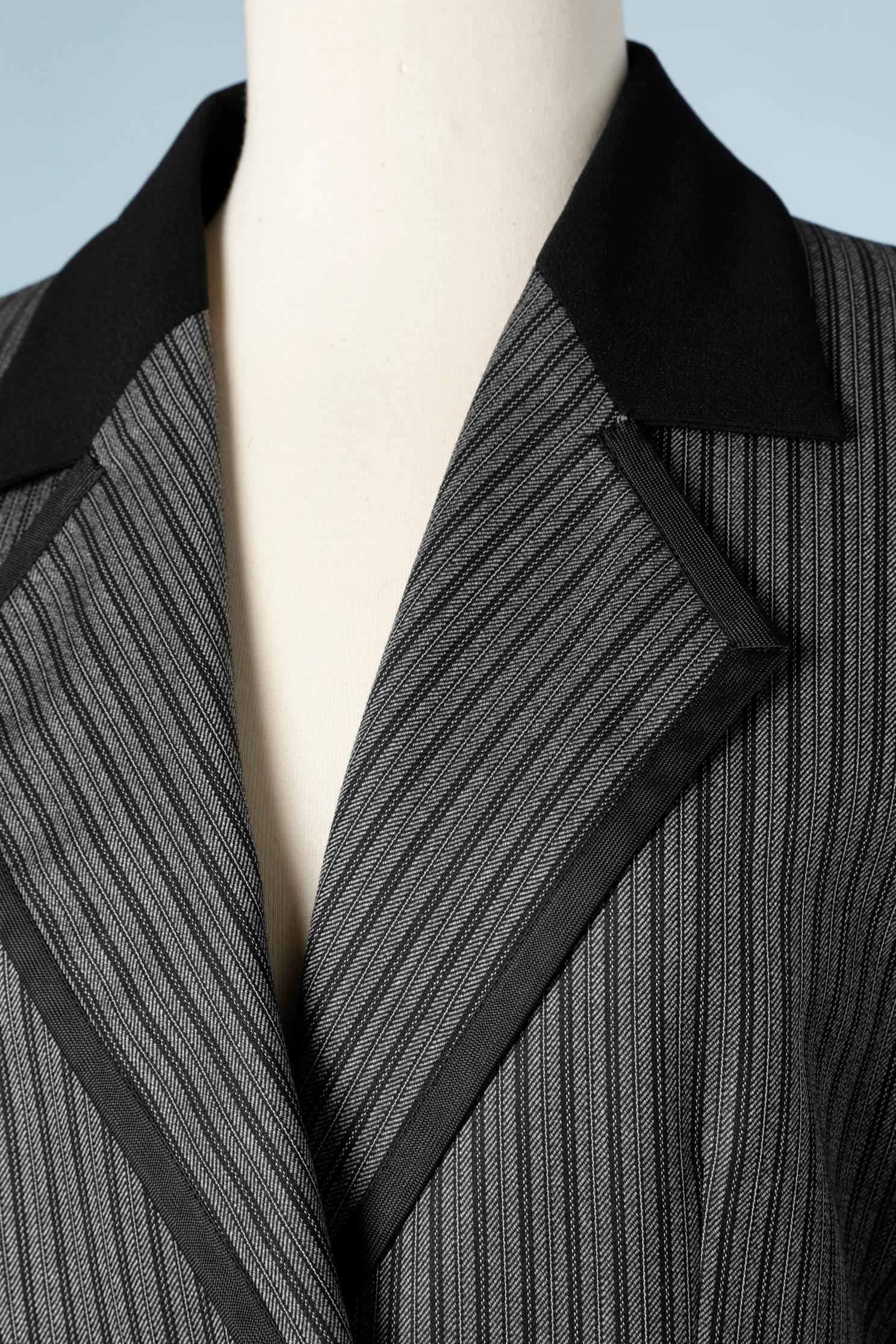 Jupe rayée en laine noire et grise - costume. Bordure passepoilée noire. Bouton supplémentaire fourni. 
TAILLE 38 (M) 