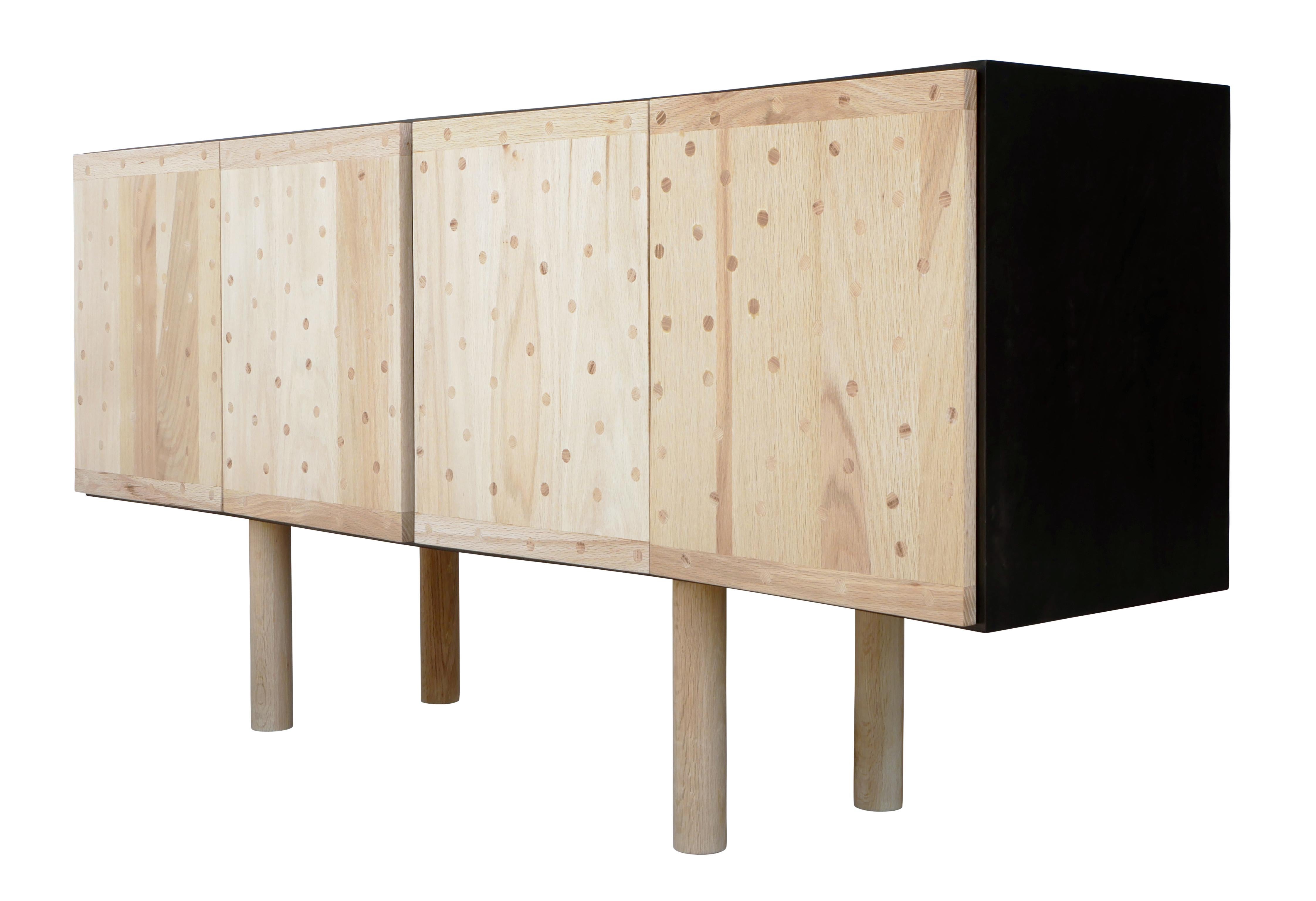 Custom Reeves Art + Design natural and black postmodern with cylindrical legs. The sideboard doors feature circular wood inlays that create interest and is paired with the sleek and smooth legs, balancing the overall soft and sharp elements of this