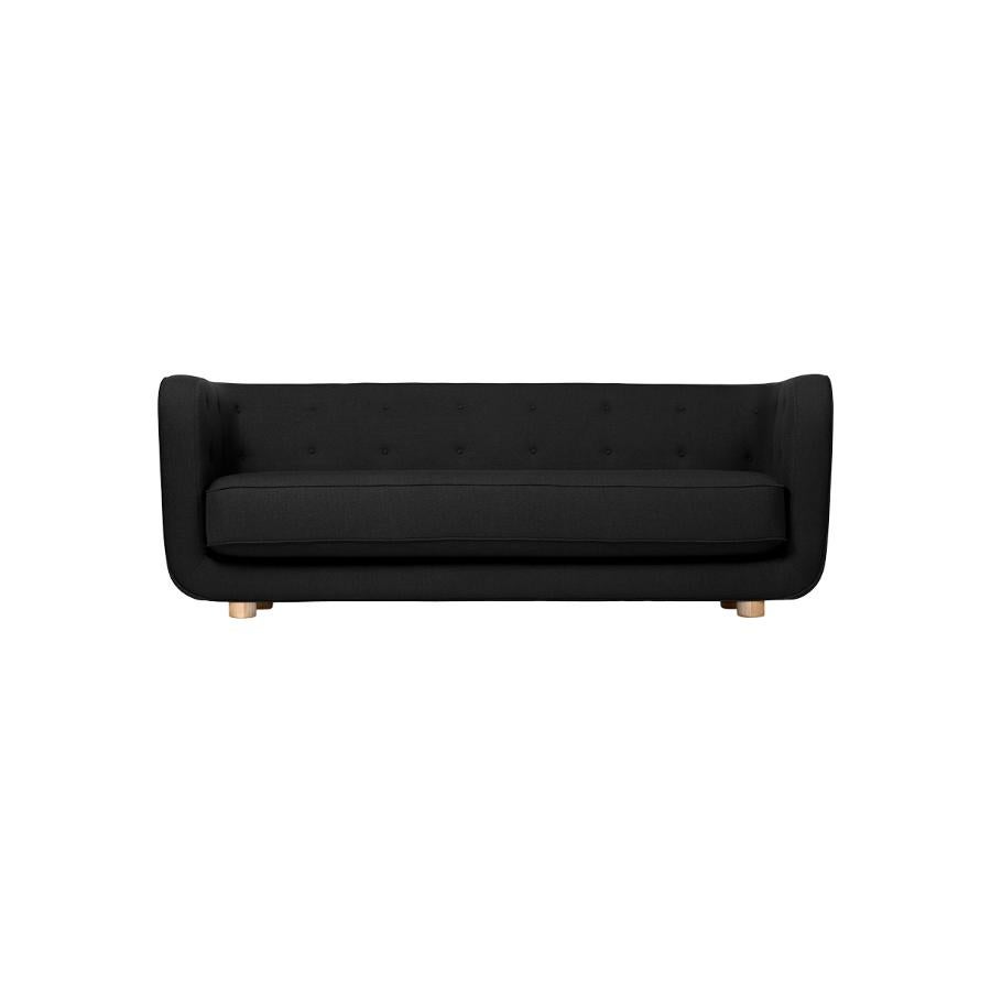 Black and natural oak Raf Simons Vidar 3 Vilhelm sofa by Lassen.
Dimensions: W 217 x D 88 x H 80 cm. 
Materials: Textile, Oak.

Vilhelm is a beautiful padded three-seater sofa designed by Flemming Lassen in 1935. A sofa must be able to function