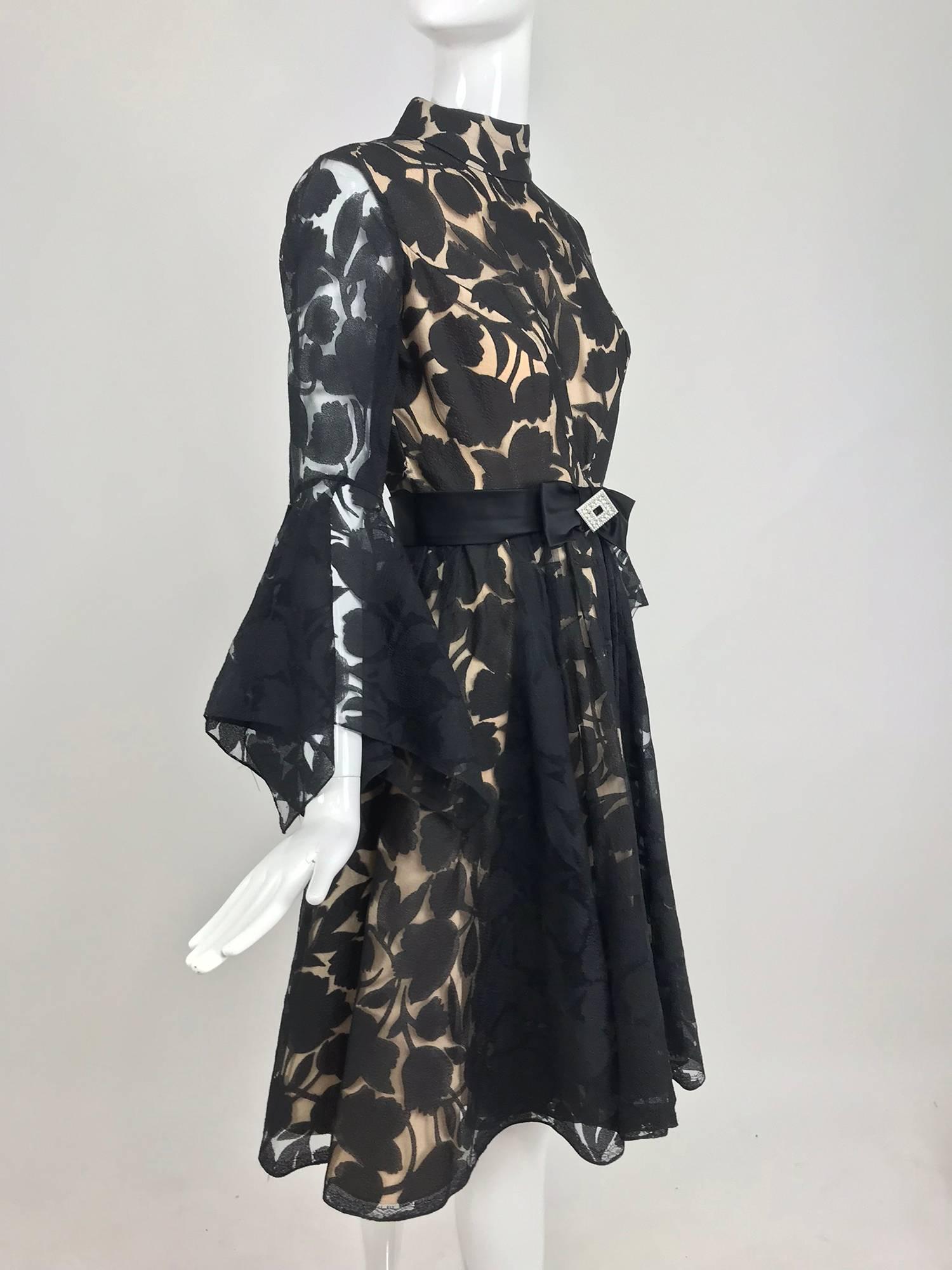 Black and nude voided organza handkerchief sleeve dress from the early 1960s...Dressmaker made this beautiful cocktail dress features a banded collar, fitted bodice and long sleeves with dramatic handkerchief cuffs...Seamed waist with a flared skirt