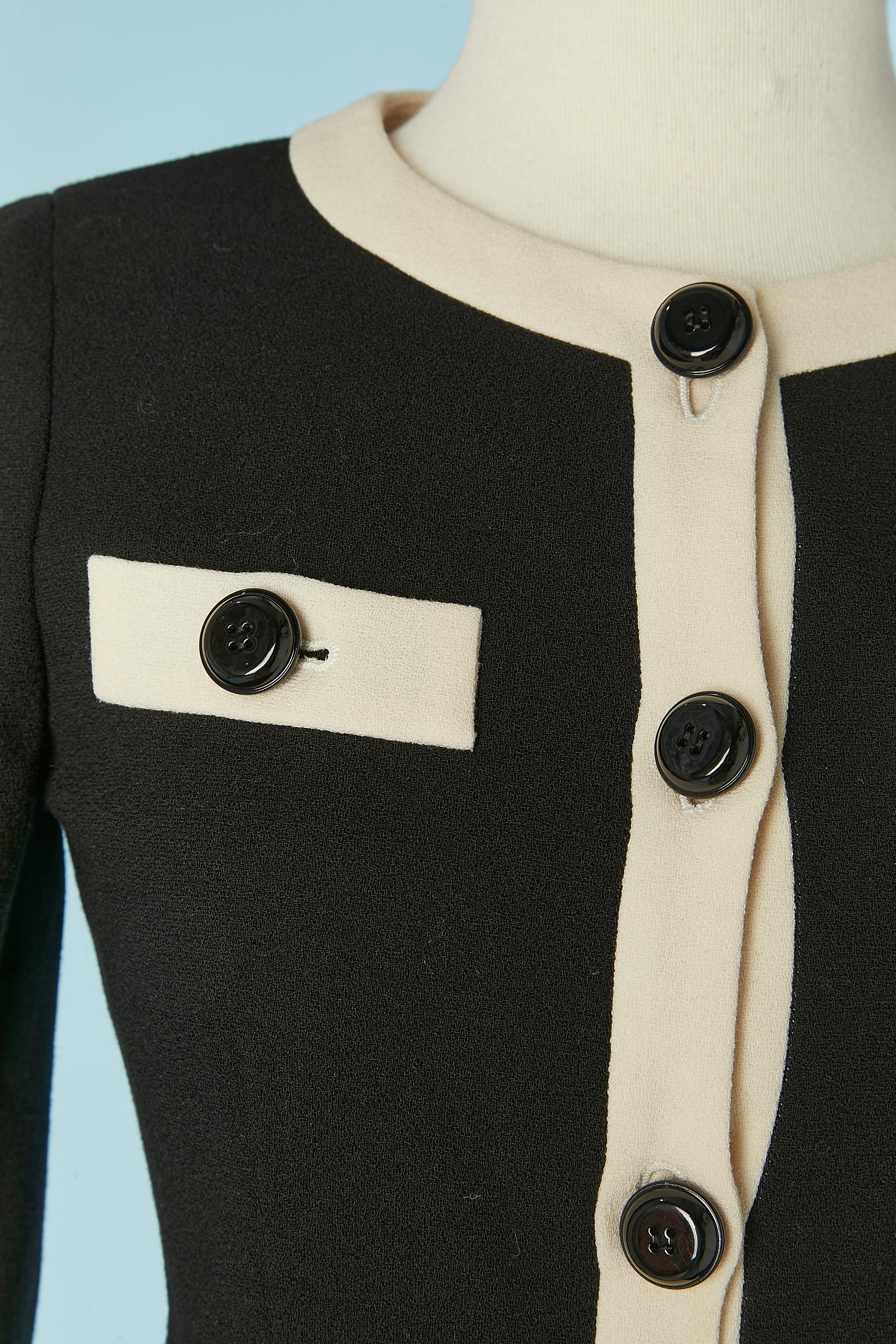 Black and off-white single breasted jacket. Main fabric composition: wool crêpe . Lining composition: 60% acetate, 40% rayon. Shoulder pad. Button and buttonhole closure on the middle front and on the cuffs. The pocket are 