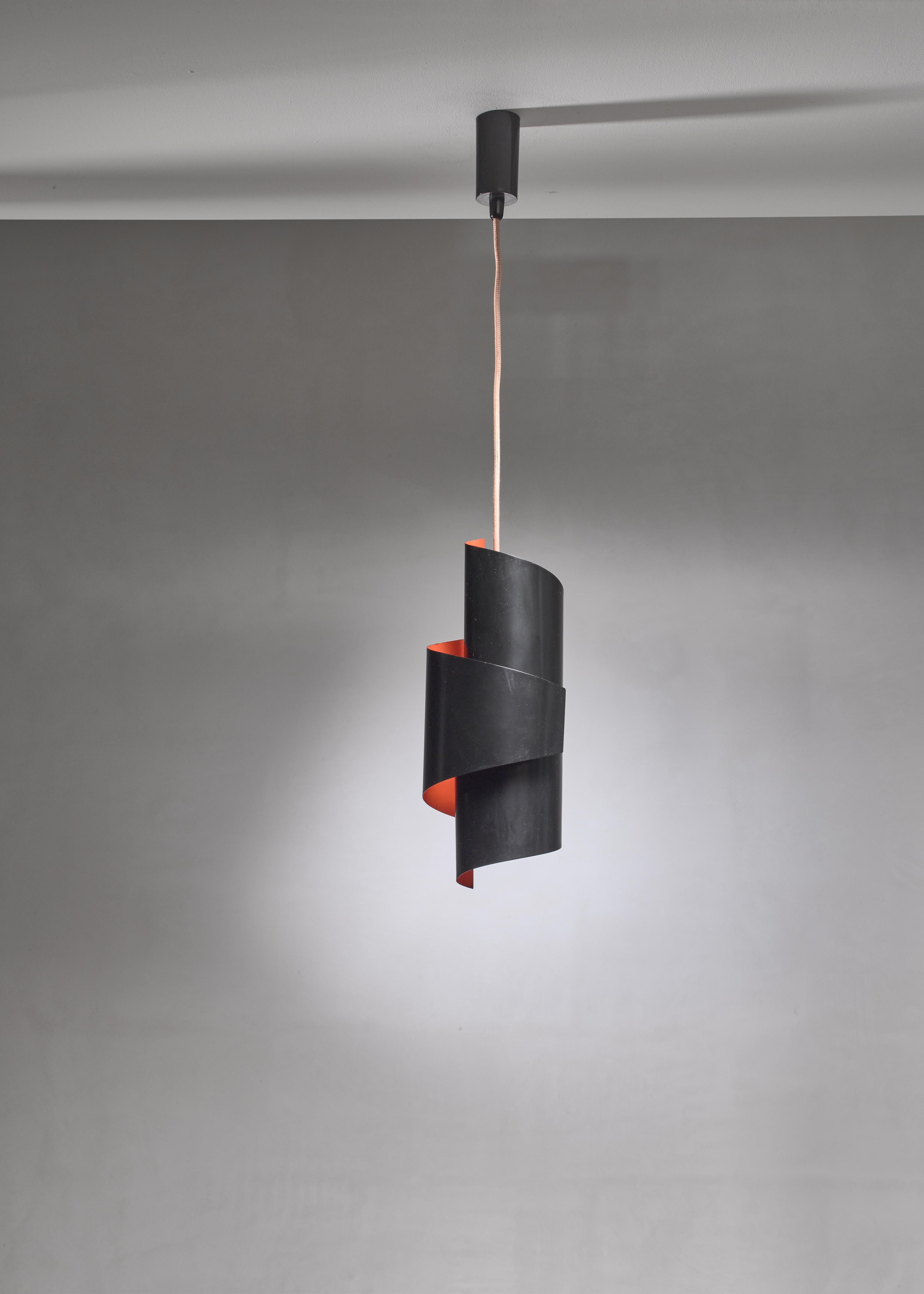 A swirl shaped pendant lamp from the 1960s by Simon Henningsen, made of bent sheet metal, painted black on the outside and orange on the inside, giving it a beautiful warm light.

The total drop can be adjusted to your requirements. We also have a