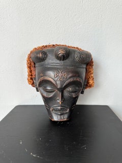 Schwarze und orangefarbene Stammesmaske