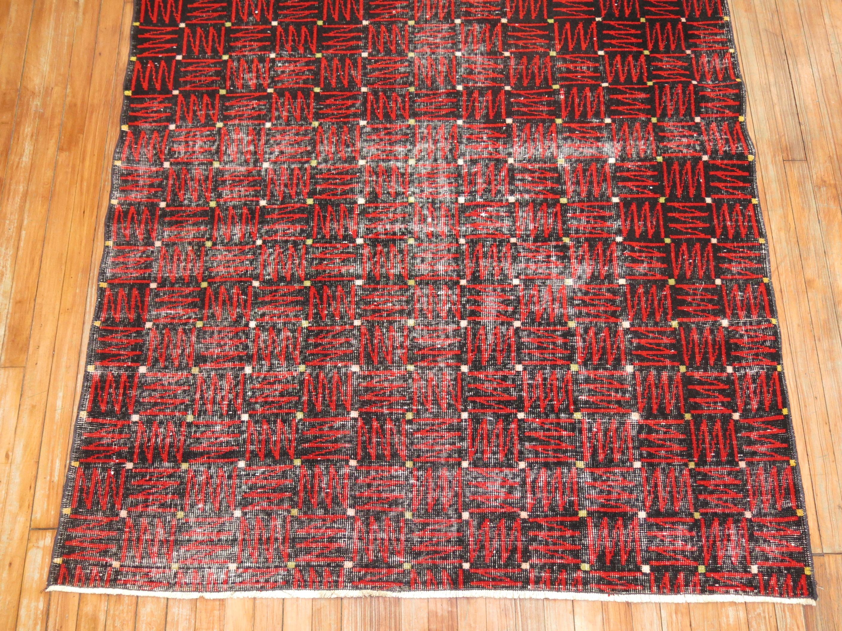 Ein schicker türkischer Deko-Teppich aus der Mitte des 20. Jahrhunderts mit einem futuristischen, sich wiederholenden Muster in Schwarz und Rot. Altersbedingte Abnutzung.