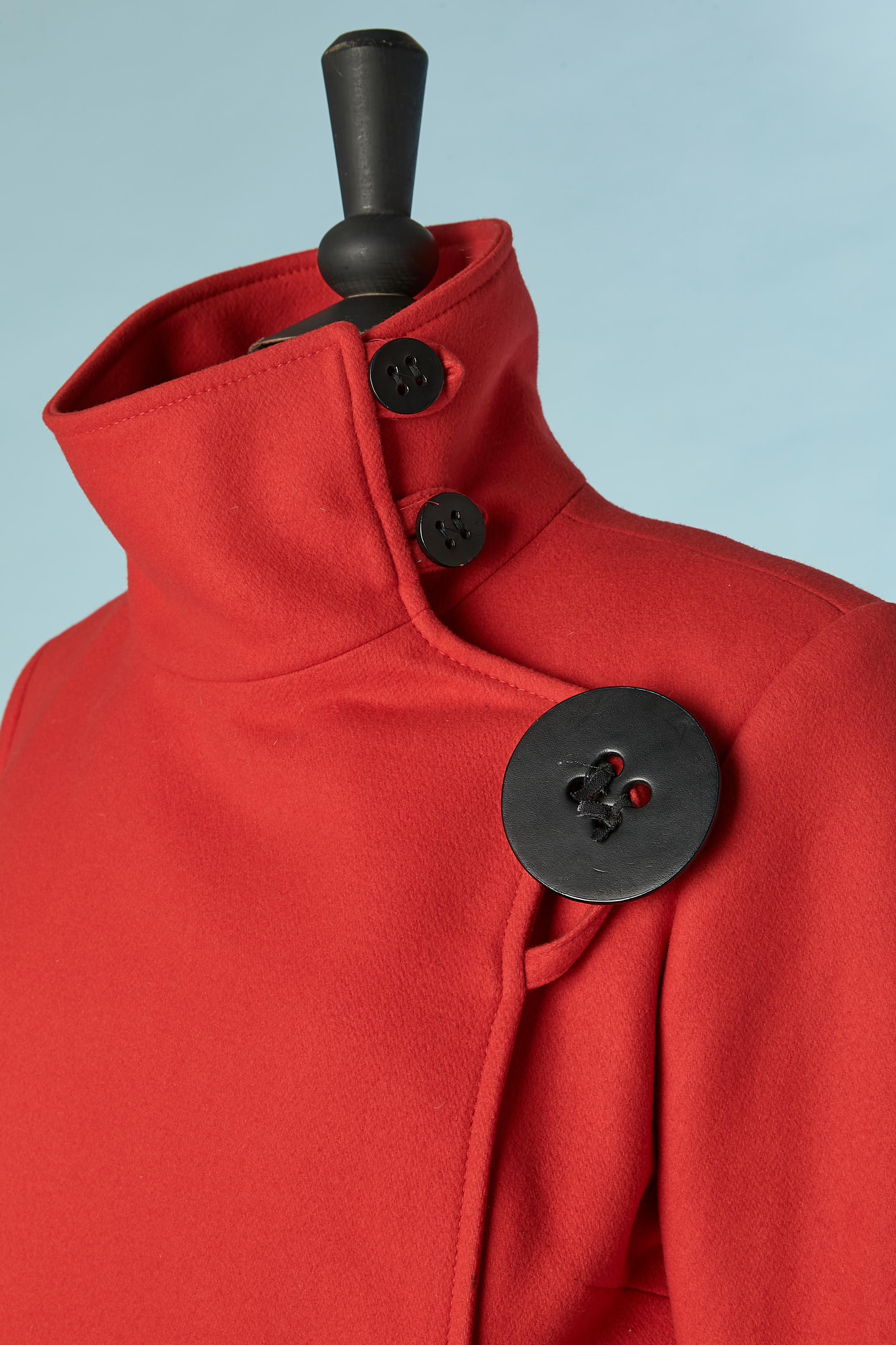 Cappotto doppiopetto nero e rosso  con pulsante nero. Composizione del tessuto della scocca: 75% lana, 15% nylon, 10% lana vergine.  
Fodera: 100% rayon. 
Spallaccio. Chiusura con bottoni e asole + un bottone nascosto. Tasca su entrambi i lati.