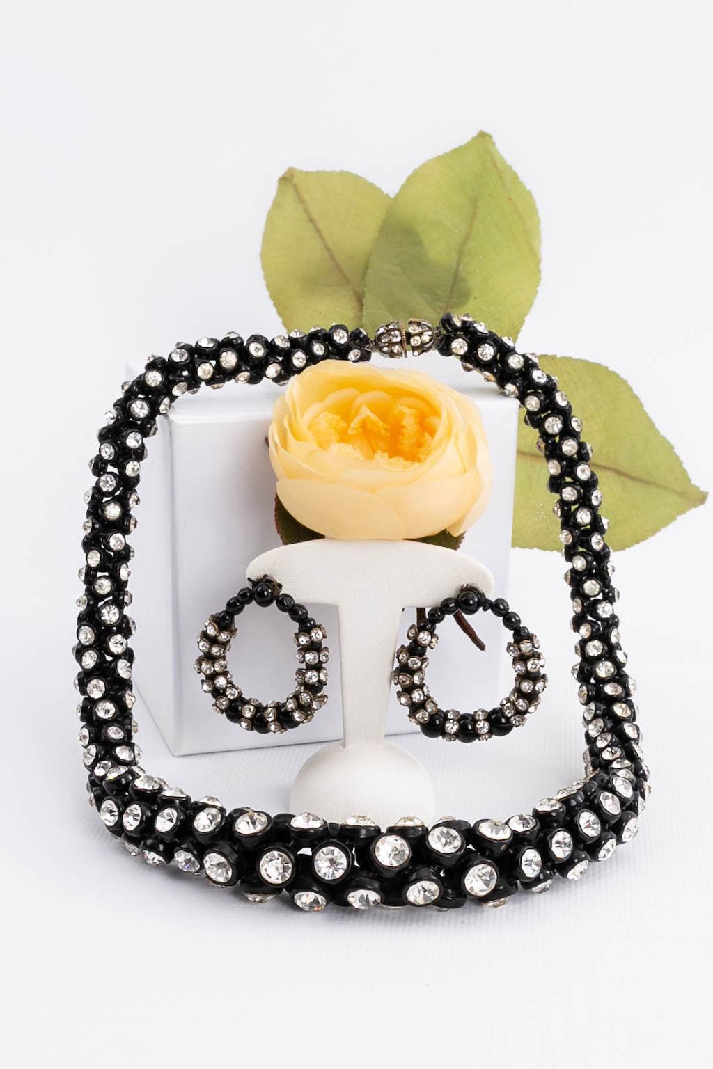 (Made in France) Set comprised of an articulated necklace and matching earrings, in black lacquered metal and rhinestones. Solid silver clasp. No signature. Circa1930s.

Additional information:
Condition: Very good condition
Dimensions: Necklace