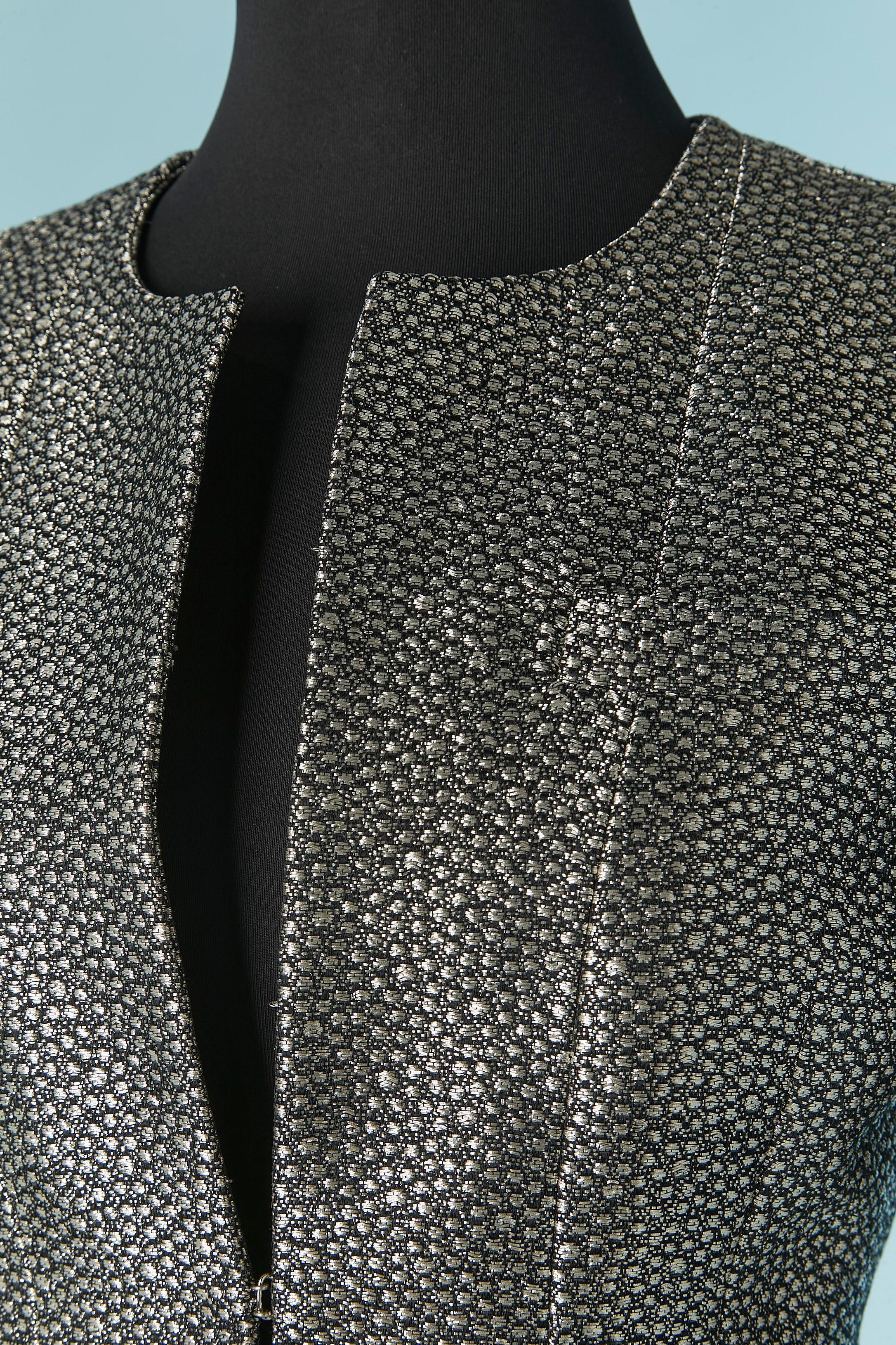 Giacca jacquard in lurex nero e argento da un bordo all'altro. Composizione del tessuto principale: 39% metallo, 27% seta, 19% rayon, 13% lana, 2% nylon. Fodera: 95% seta, 5% elastan. 
Chiusura con gancio e occhiello al centro della parte anteriore.