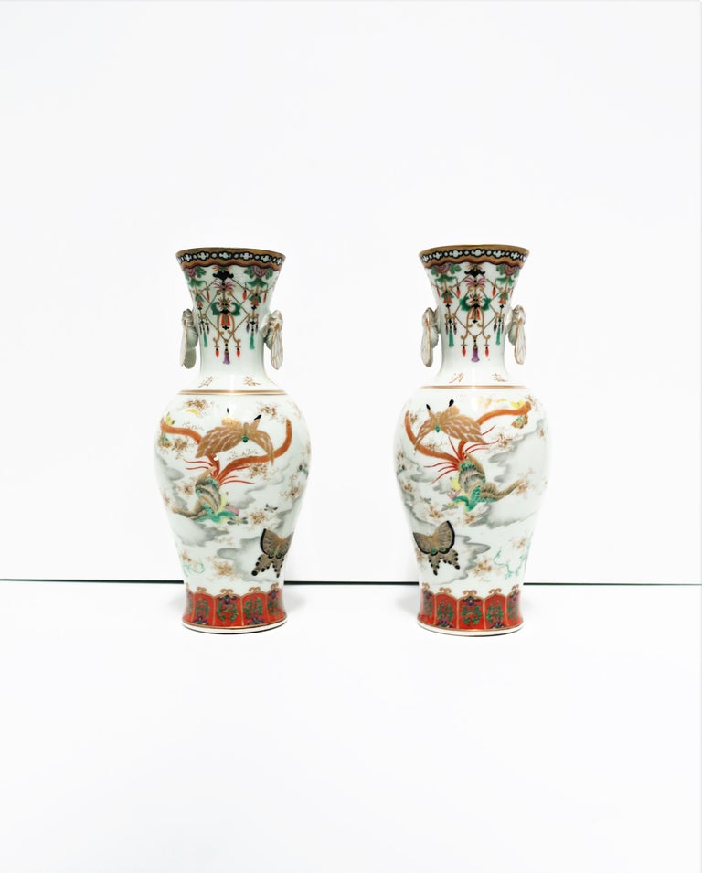 A very beautiful pair of polychromed Kutani porcelain Japanese vases, circa early 20th century, Meiji period, Japan. Vases are hand painted and designed with two different sides; one side floral, the other with birds and butterflies. Beautiful Art