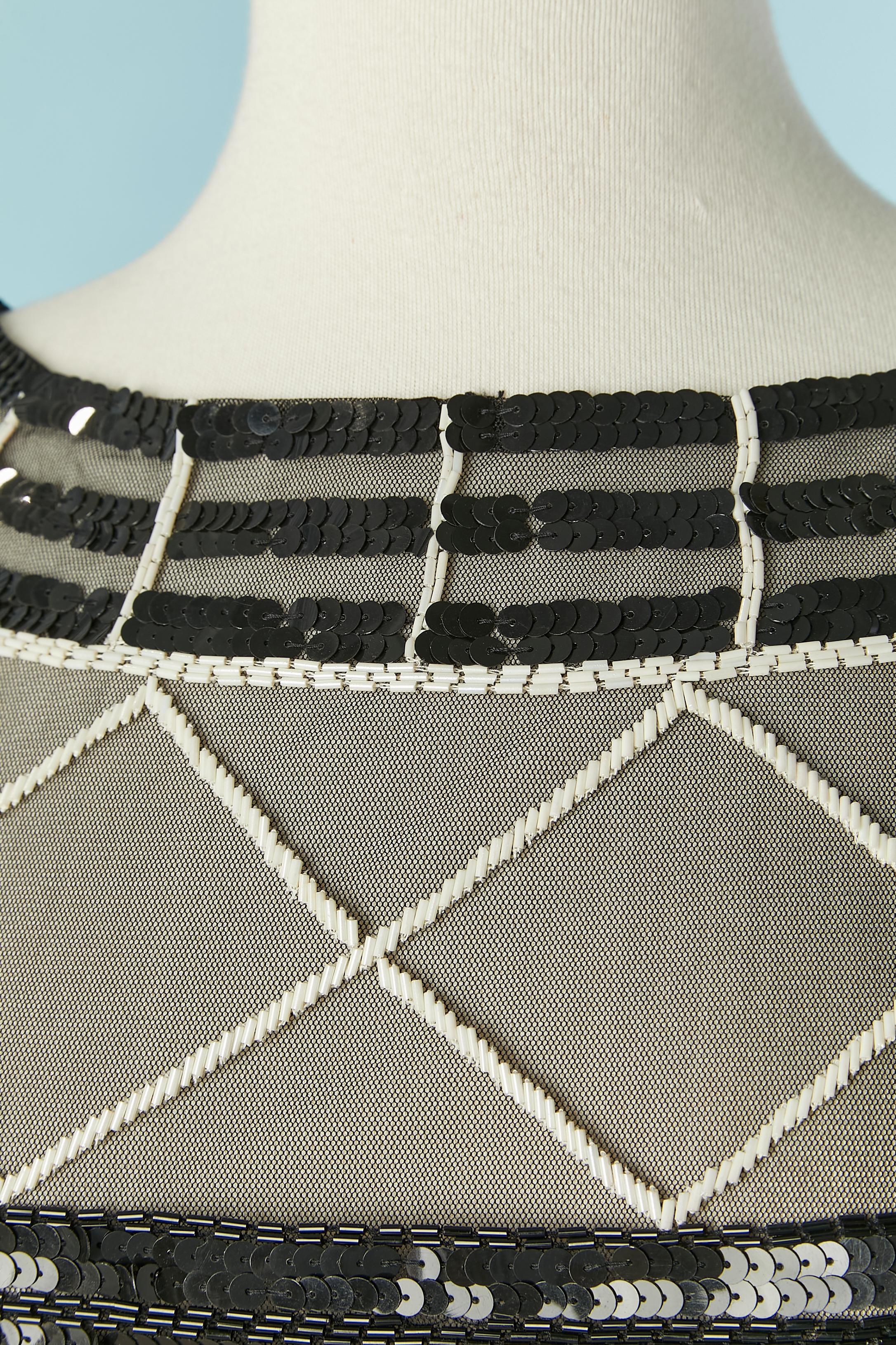 Top in tulle nero e bianco con perline e chiusura a zip sul lato sinistro. 
TAGLIA M 
