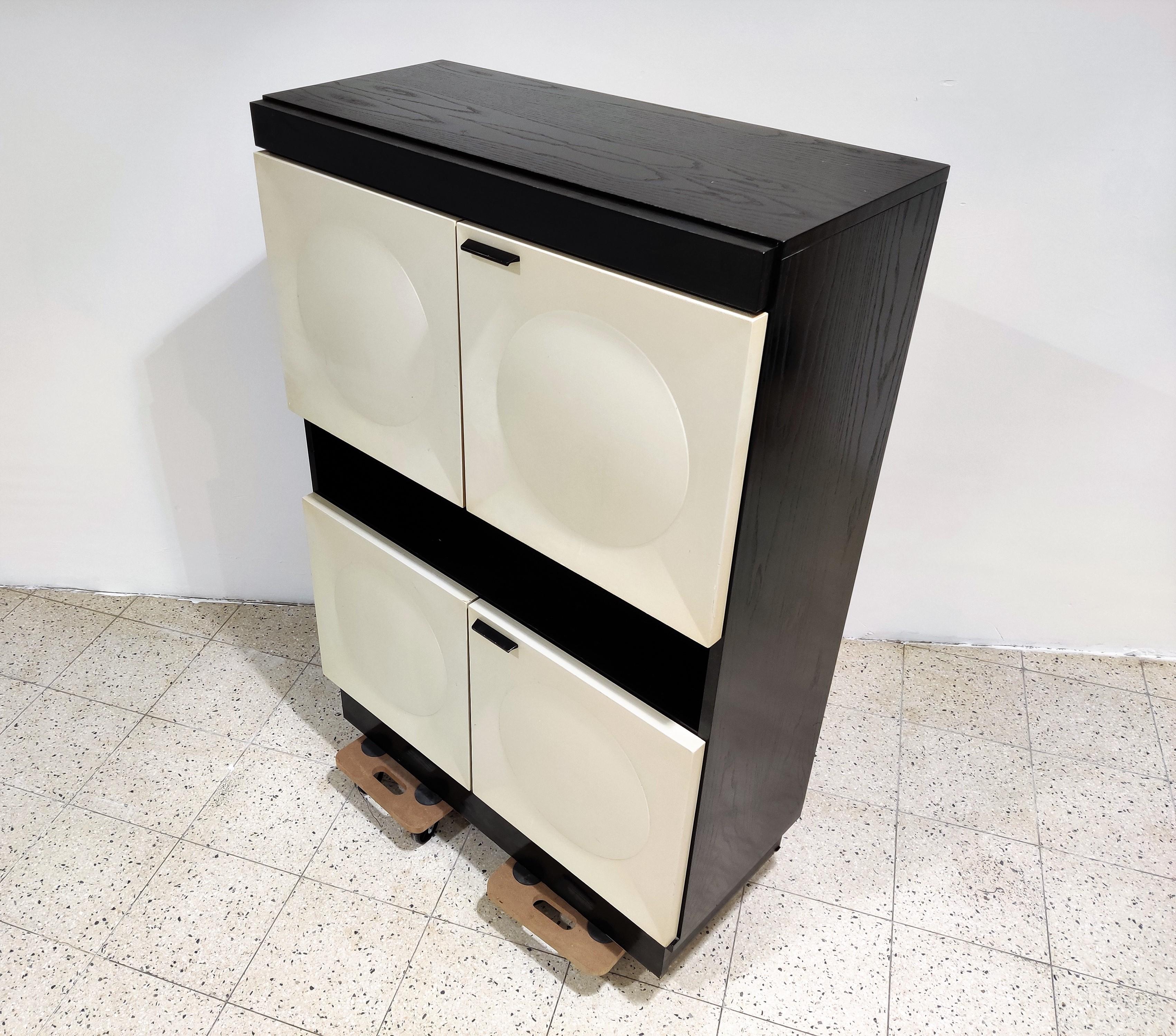 Beautiful black wooden Brutalist bar cabinet with 4 white lacquered doors.

The cabinet has a light on the inside.

Beautiful timeless design.

Good condition.

1970s, Belgium

Dimensions:
Height 145cm/57.08