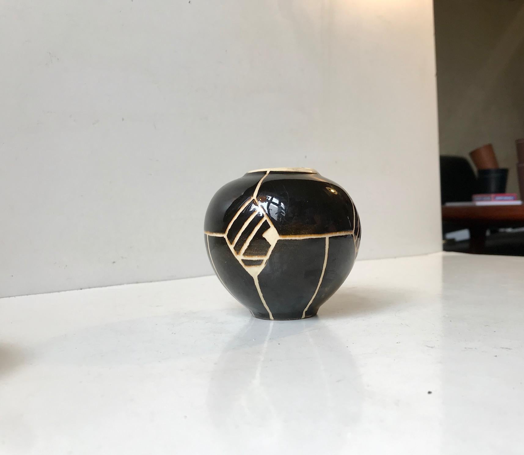 Small Ball shaped ceramic vase in black and creamy white glazes. Its executed with geometric motifs. It was made by Knabstrup in Denmark during the 1920s or 30s in a style derived from the French and German Art Deco era pottery.