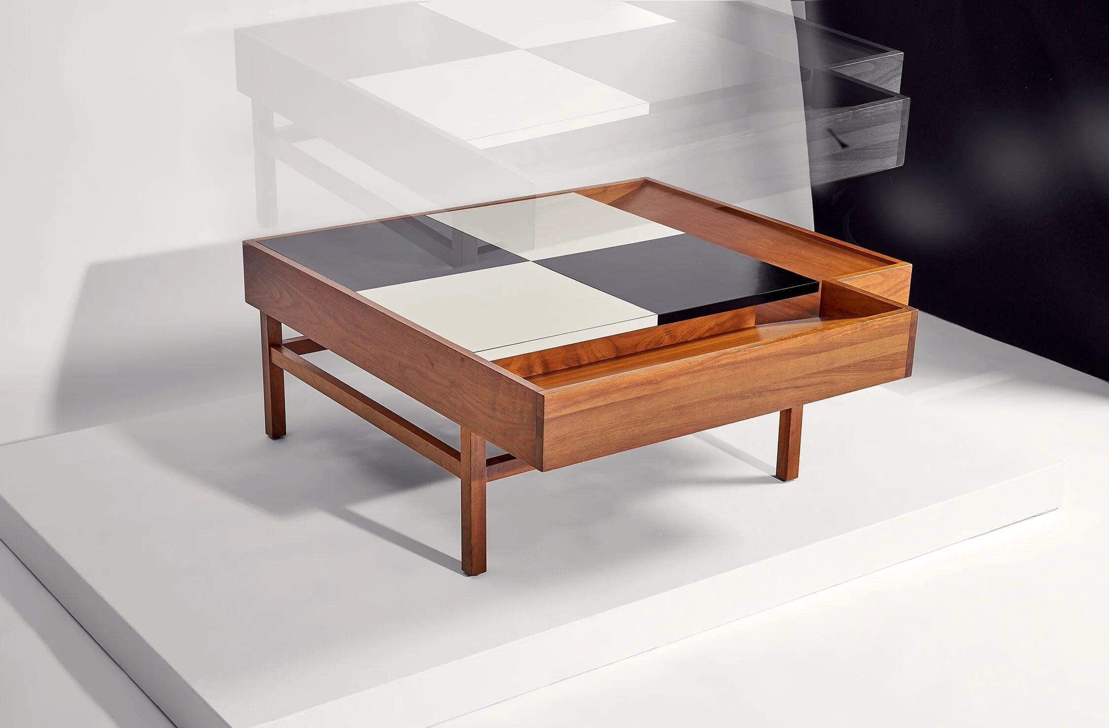 Table basse géométrique conçue par John Keal pour Brown Saltman
USA circa 1950's

Base en noyer avec deux côtés allongés inclinés pour la présentation de livres
La surface en damier noir et blanc en stratifié s'ouvre pour révéler un espace de