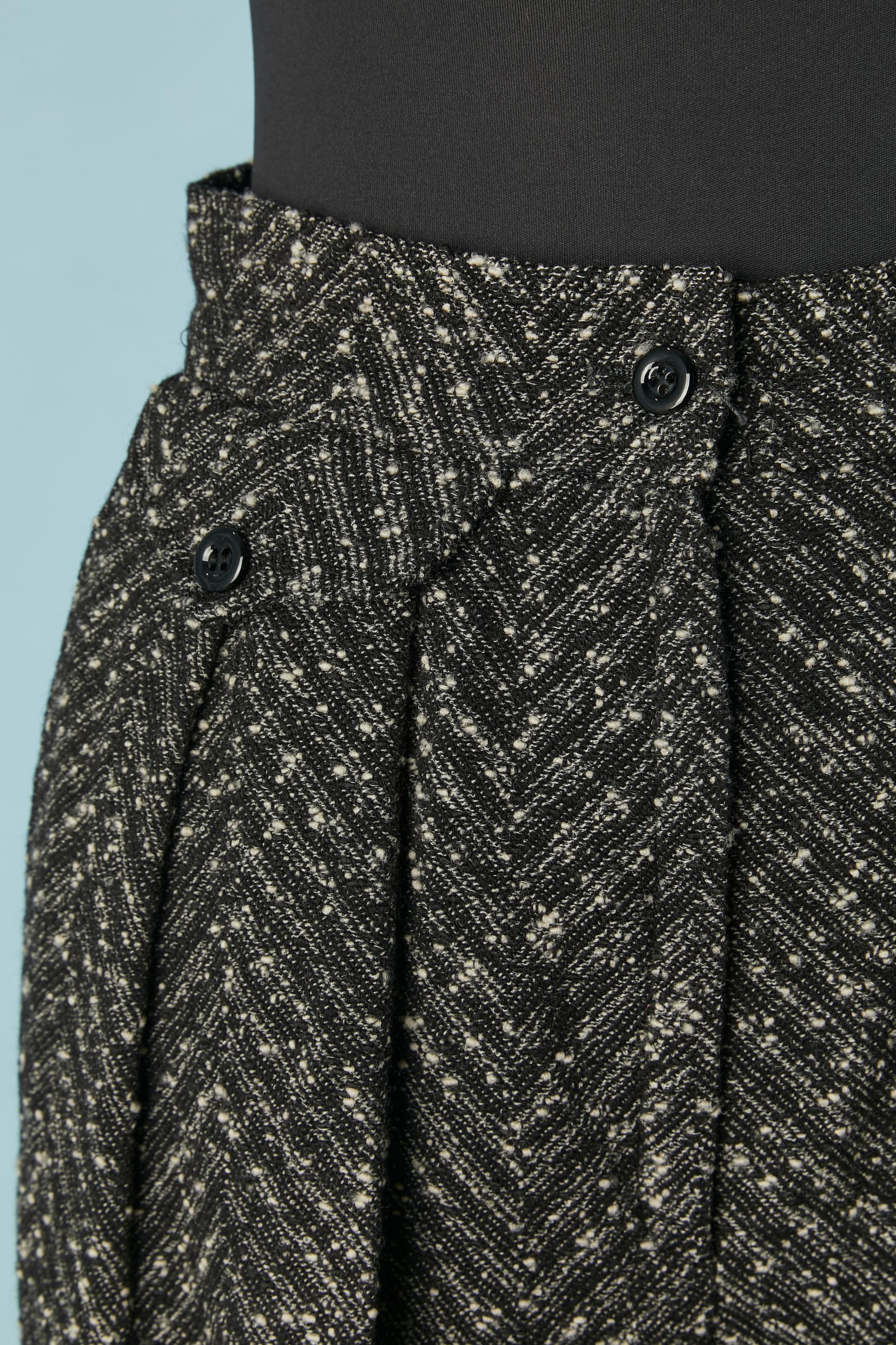 Pantalone chiné bianco e nero con motivo chevron. Composizione del tessuto principale: 76% lana, 17% poliestere, 7% nylon. Non c'è l'etichetta della composizione del tessuto per la fodera, ma probabilmente si tratta di acetato o rayon. 
Tasca su