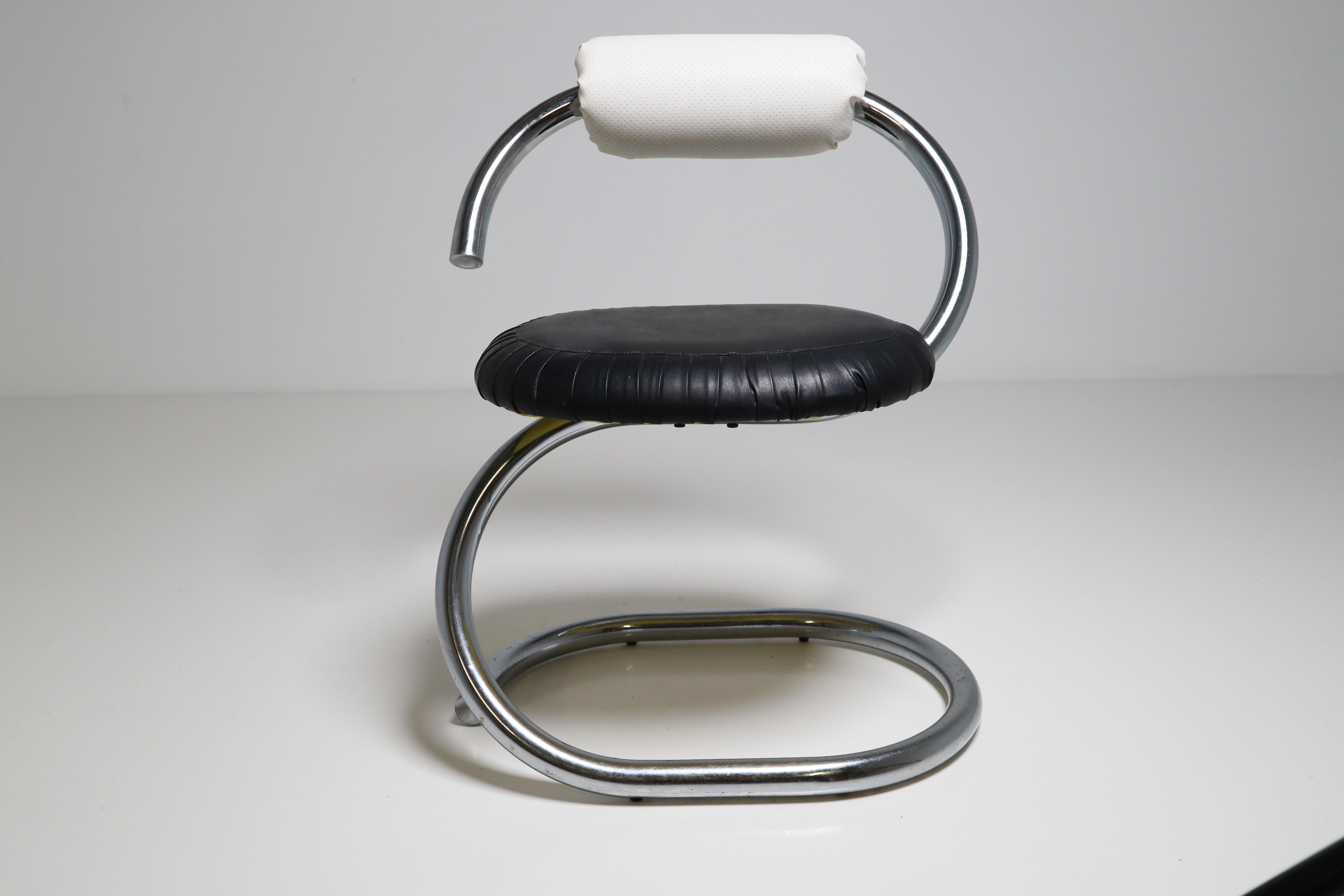 The Cobra chair was designed by Giotto Stoppino in the 1970s and consisting of a chrome metal tubular structure snaking up to the seat. The seat and back are filled with foam covered in black and white leatherette in a good vintage condition.