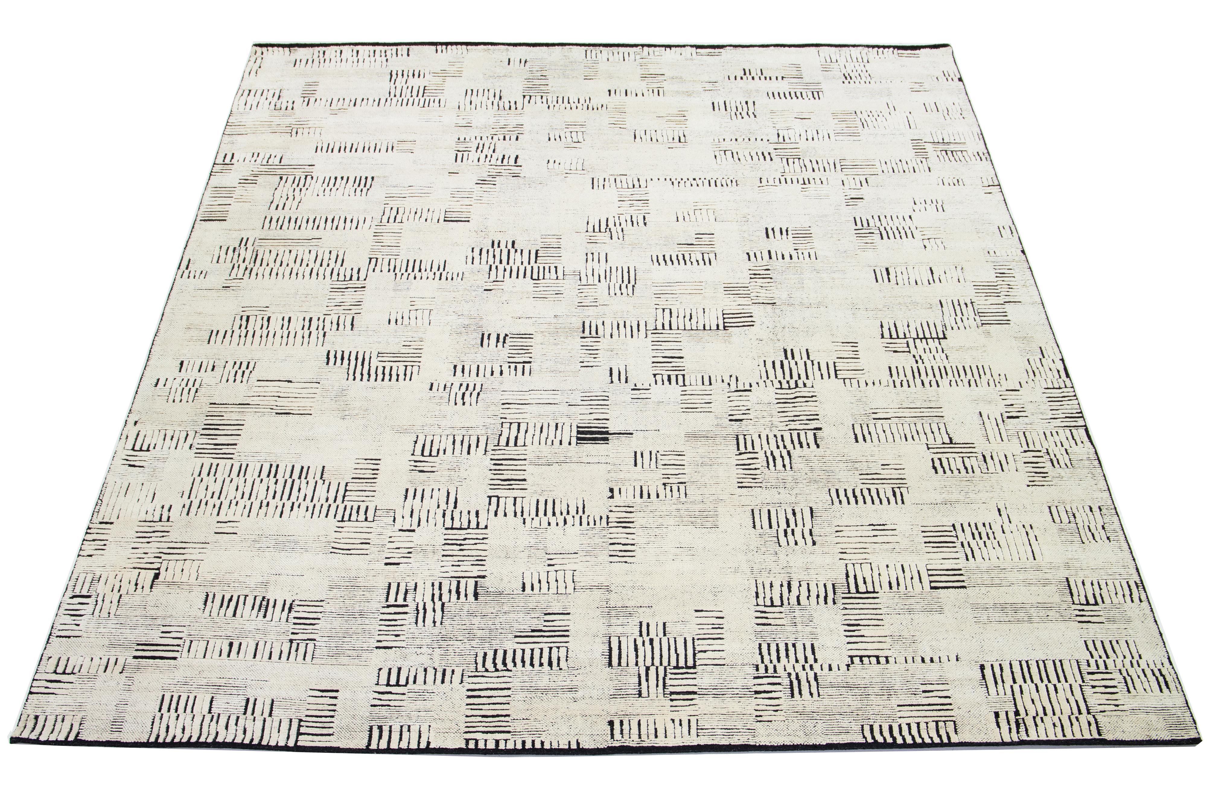 Esta moderna alfombra está anudada a mano con una mezcla de lana y seda. Su llamativo diseño combina seda blanca y lana negra por todas partes.

esta alfombra mide 12'2
