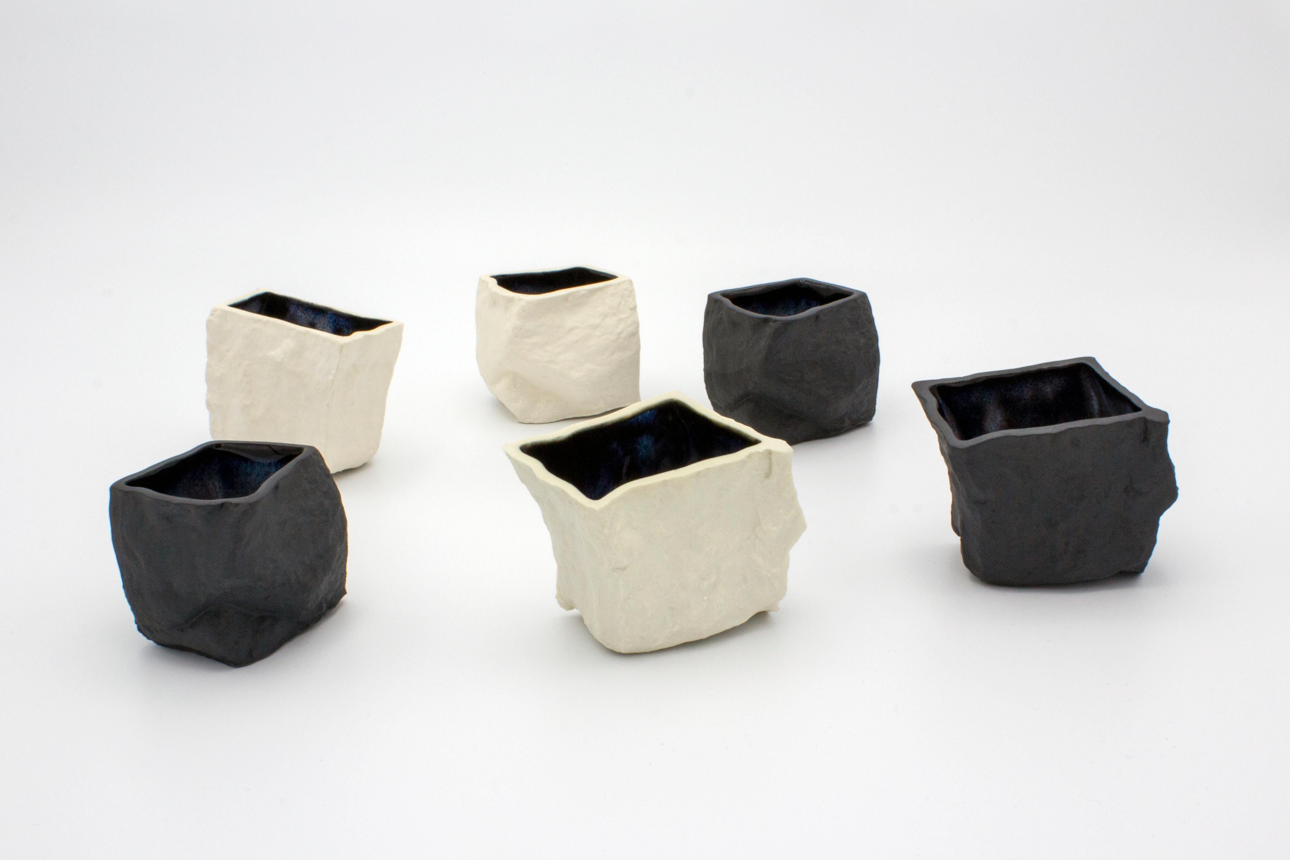 Black and white cups 6-set by Craig Barrow
Dimensions: 6 x 5 x 5.5cm
Volume approximate: 50ml

Variations:
Black porcelain, black glaze.
Black porcelain, nebular glaze.
White porcelain, white glaze.
White porcelain, nebular glaze.

A set