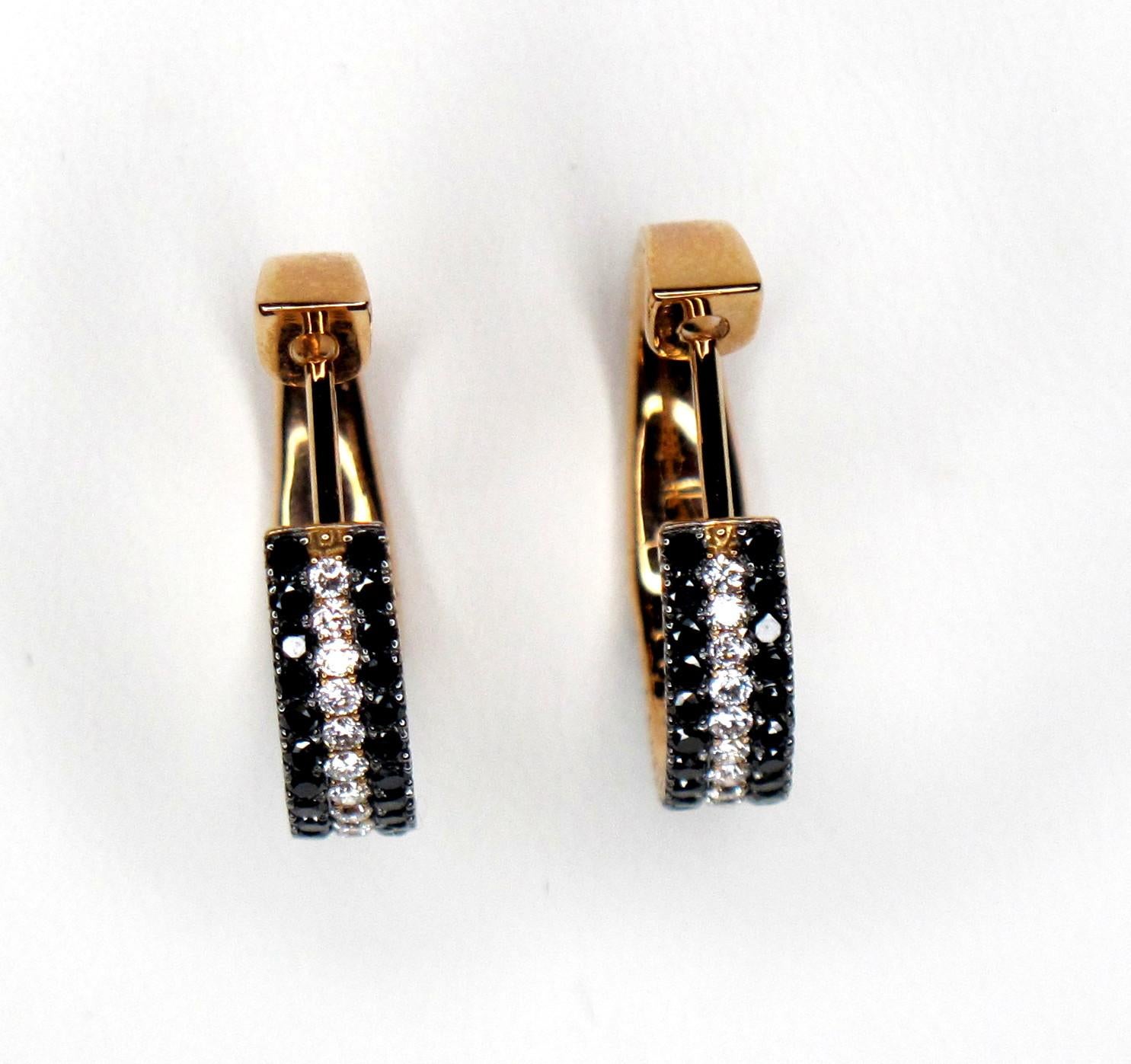 Both black and white diamonds are set in these unusual hoop style earrings. These diamonds are set in pink gold, which makes for a beautiful and unique color pairing. They are a tailored style with a modern twist!

Round brilliant cut diamonds, 1.28