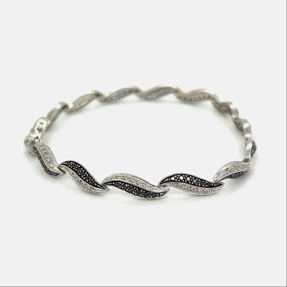 Simply Beautiful! Classic and Chic Black and White Diamond Hand crafted 14K White Gold Alternating Link Bracelet. Hand set with 82 White Diamonds, weighing approx. 0.45tcw and 82 black diamonds, approx. 0.85tcw. Bracelet measures approx. 7” long.
