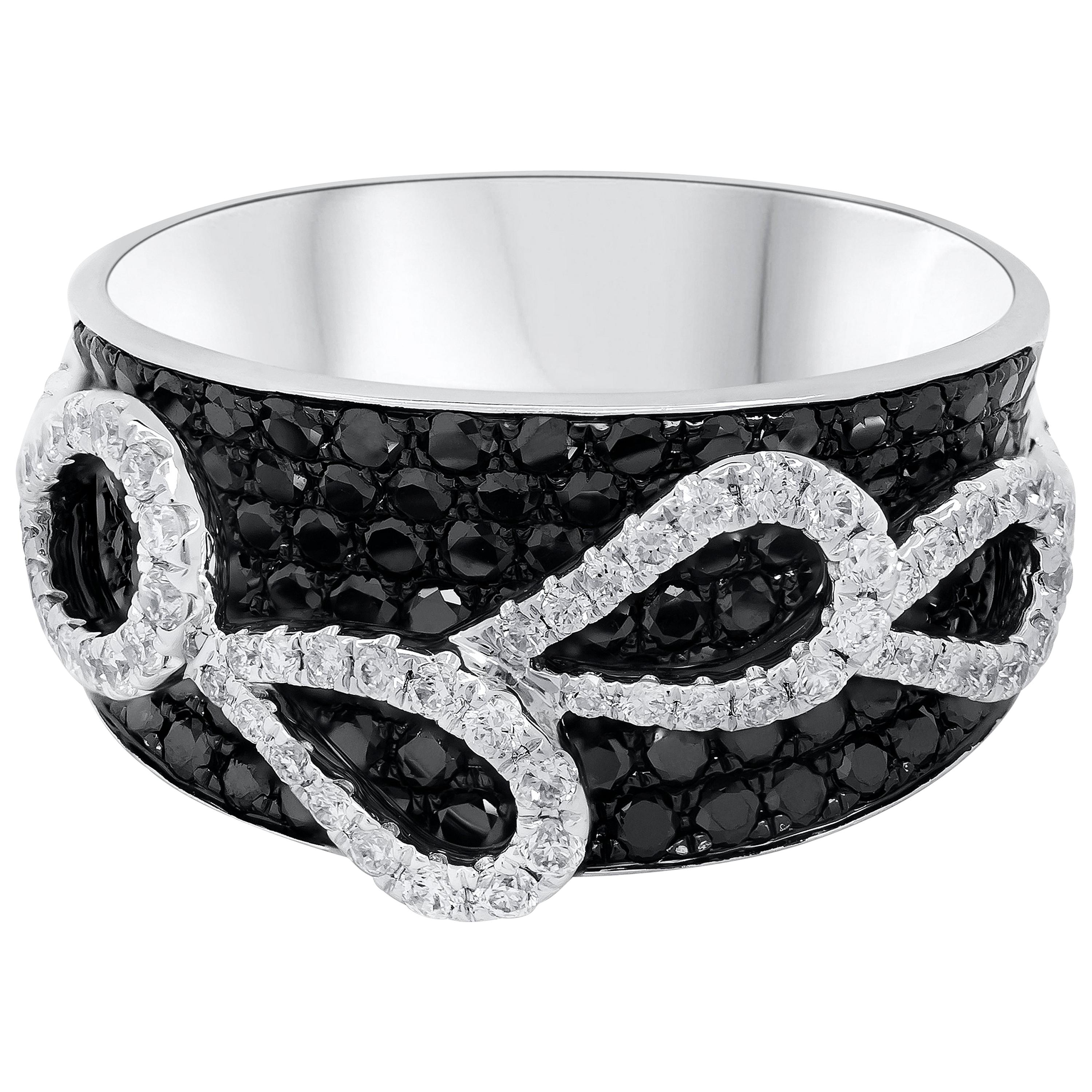 A fashionable concave fashion ring featuring 1.56 carats total of round black diamonds, set in a micro-pave dome design and 0.51 carats total of white diamonds set like a floating ribbon design. Finely made in 18K White Gold and Size 6.75 US