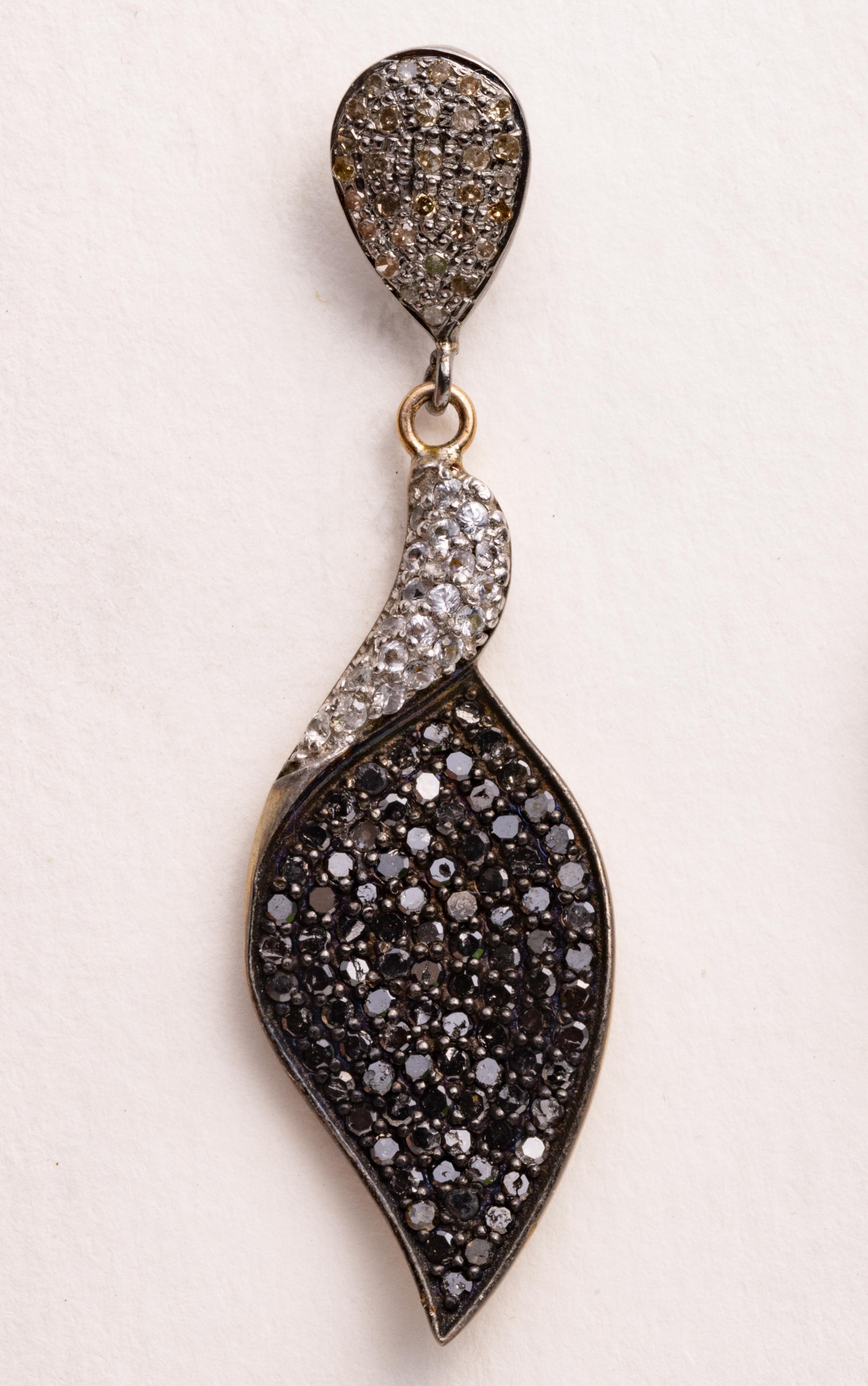 A pair of dangle earrings comprised of black and white diamonds.  All are round, brilliant cut diamonds in a pave` setting.  Set in sterling silver with an 18K gold post for pierced ears.

The fine jewelry collection is sourced, designed or created
